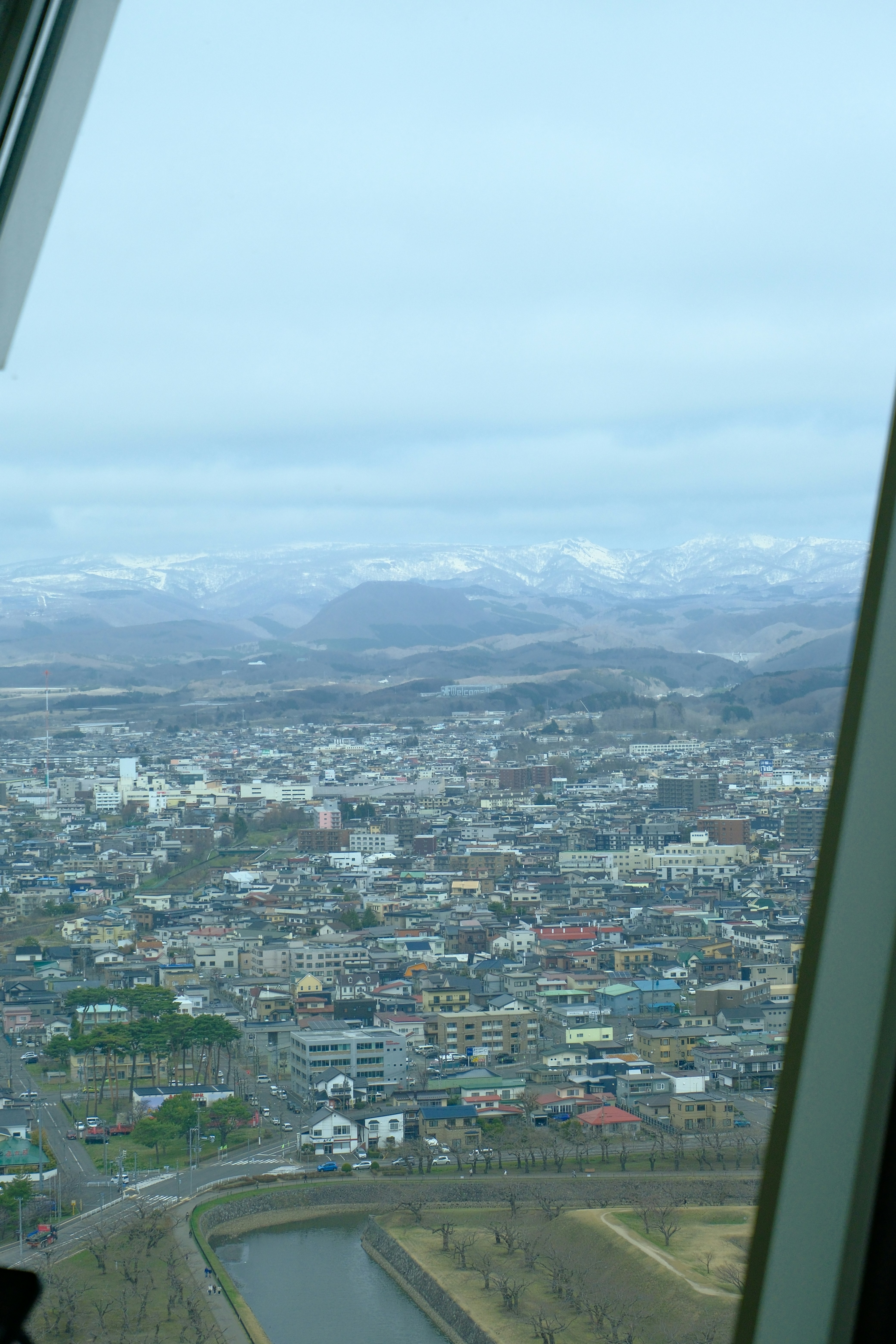 Aerial view of a sprawling city with snow-capped mountains beyond.
