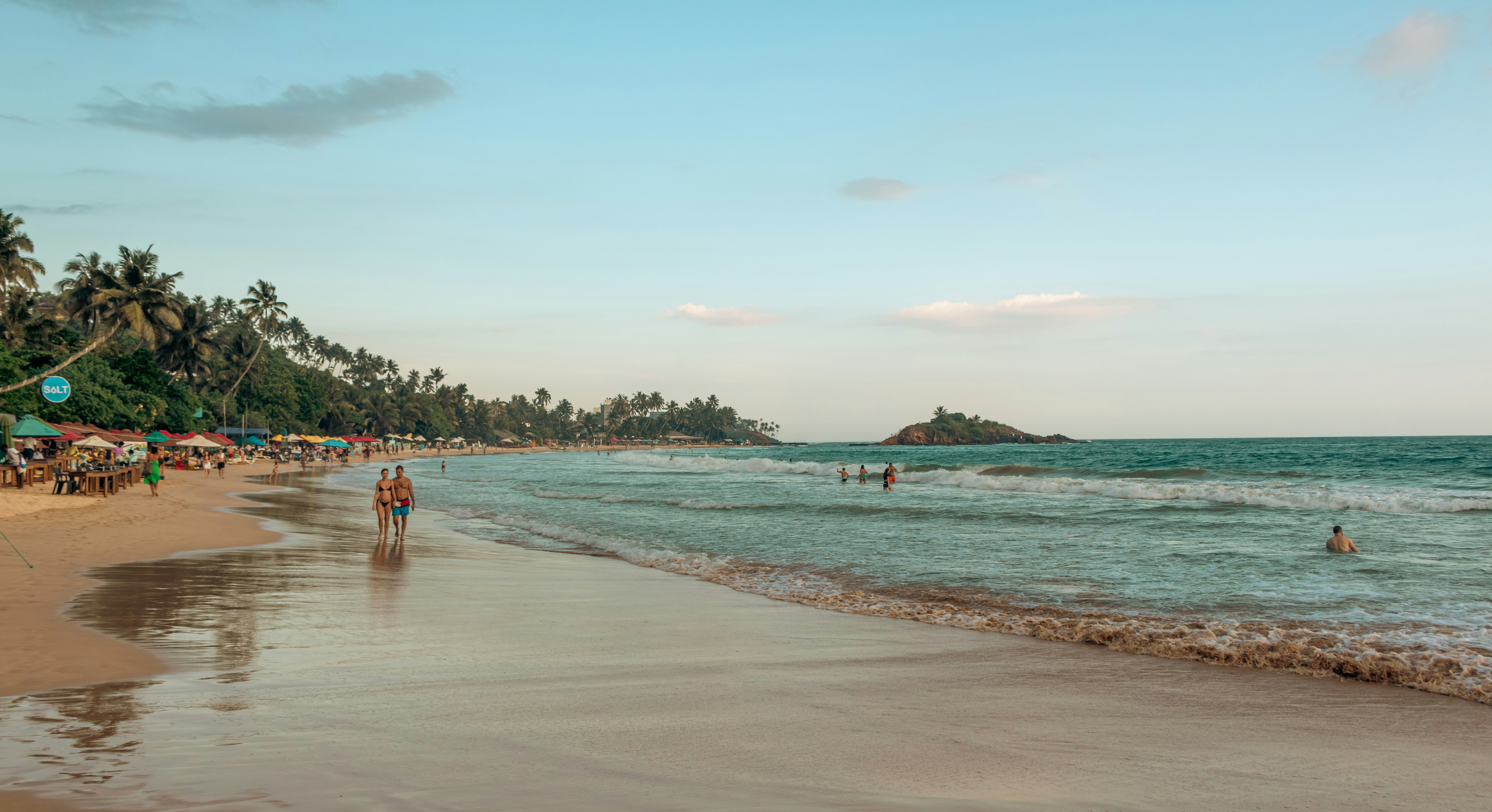 People enjoying a sunny day at a tropical beach.