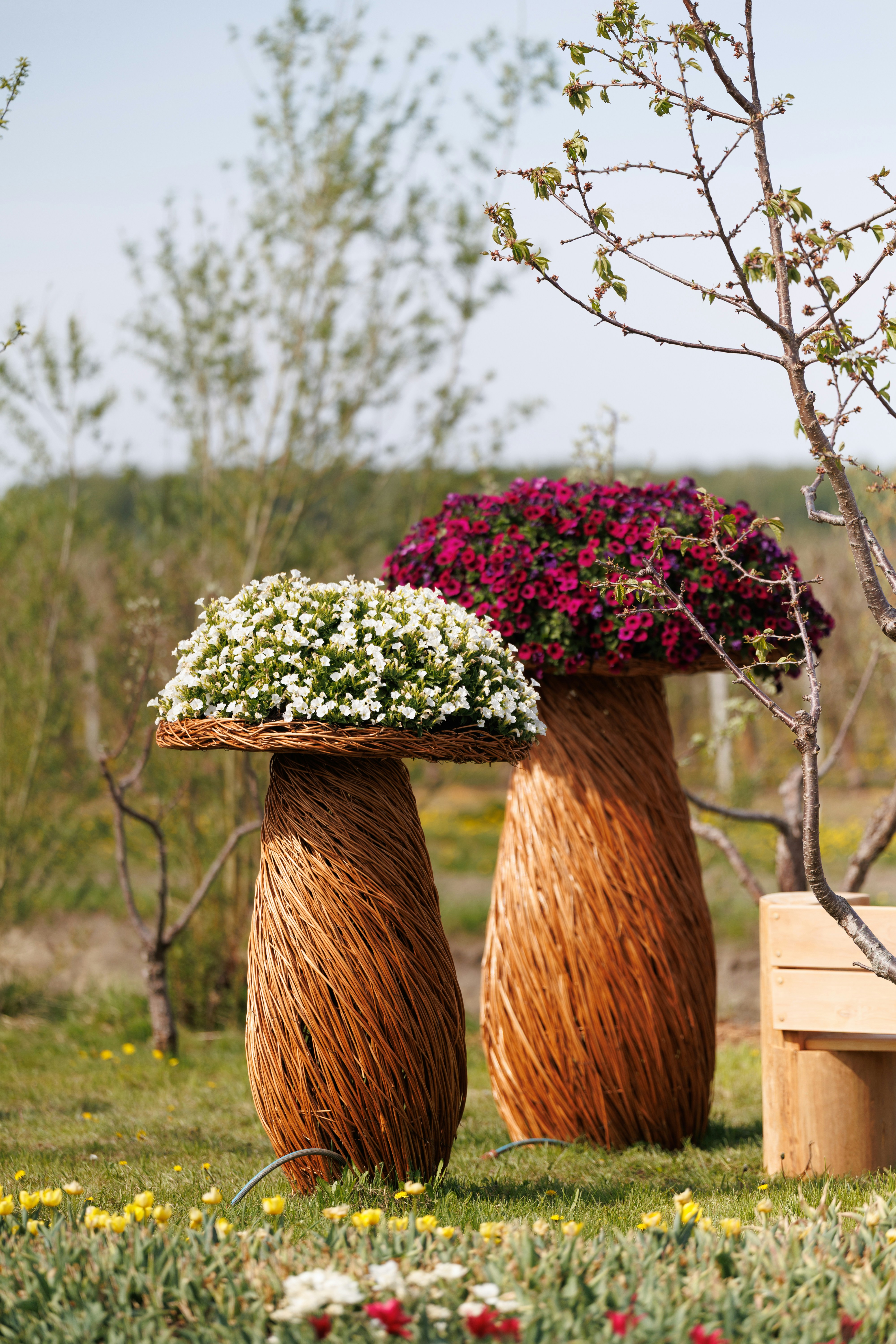 Two mushroom-shaped planters overflowing with flowers