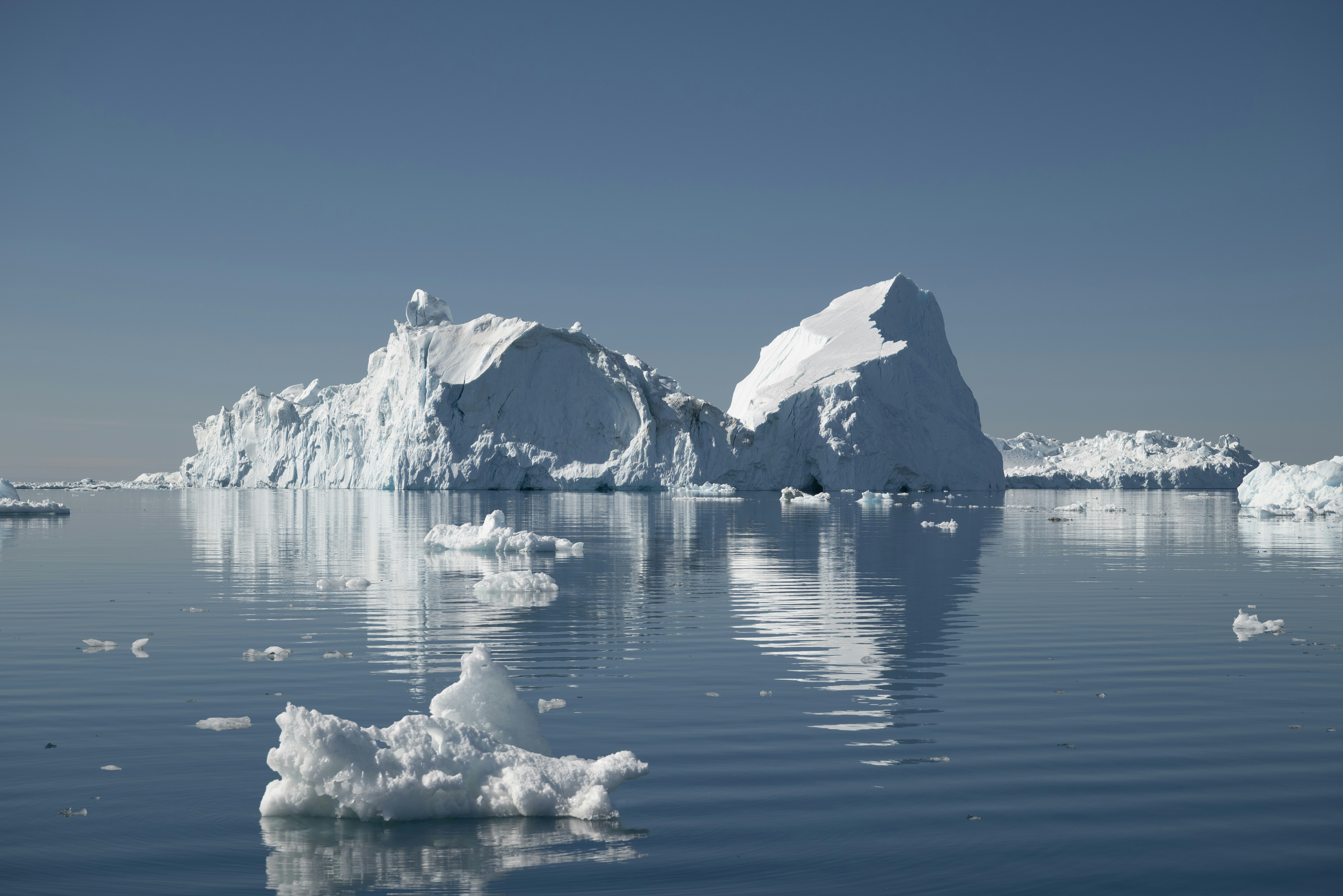 De grands icebergs flottant dans un océan bleu calme.