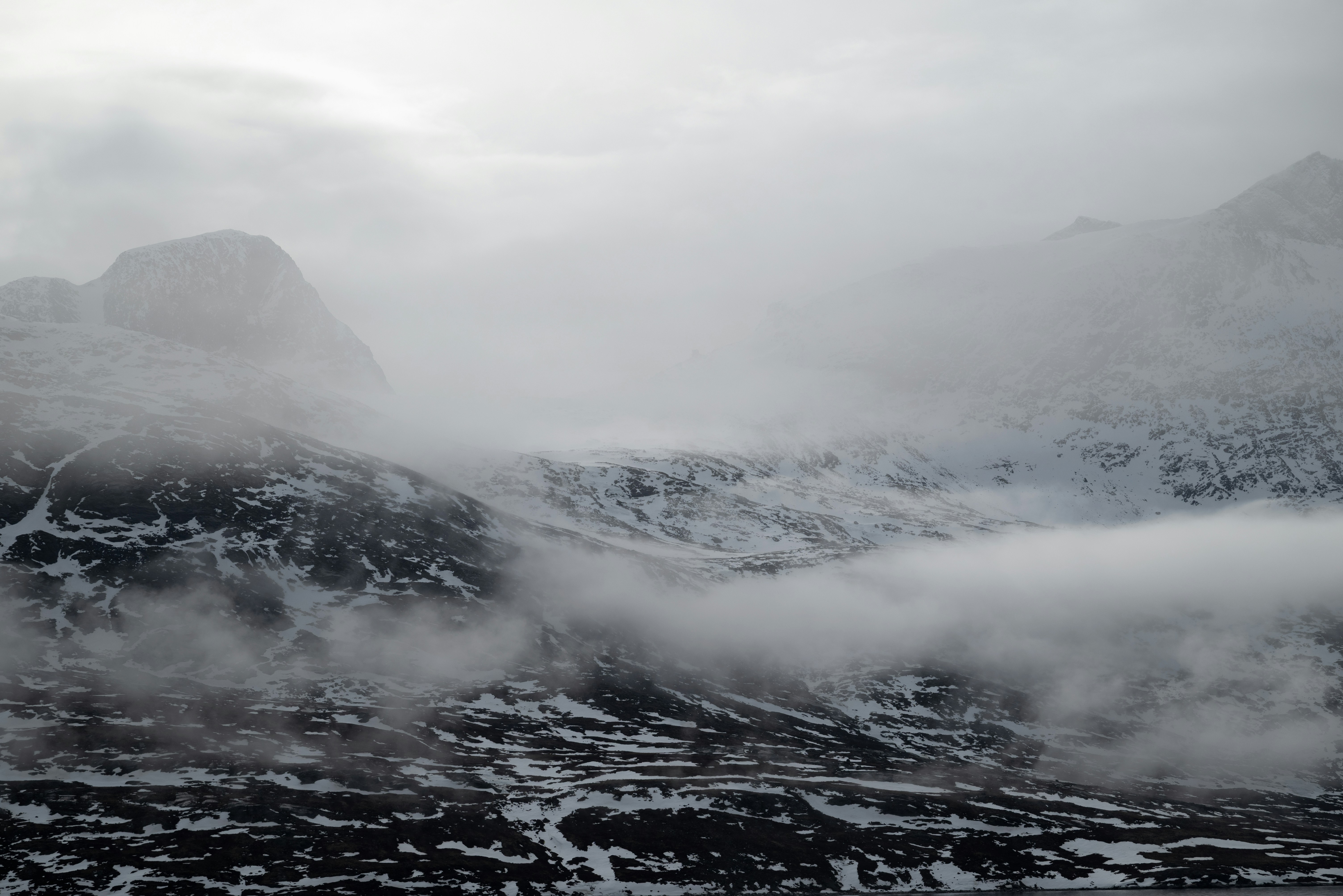 Snowy mountains shrouded in mist and clouds