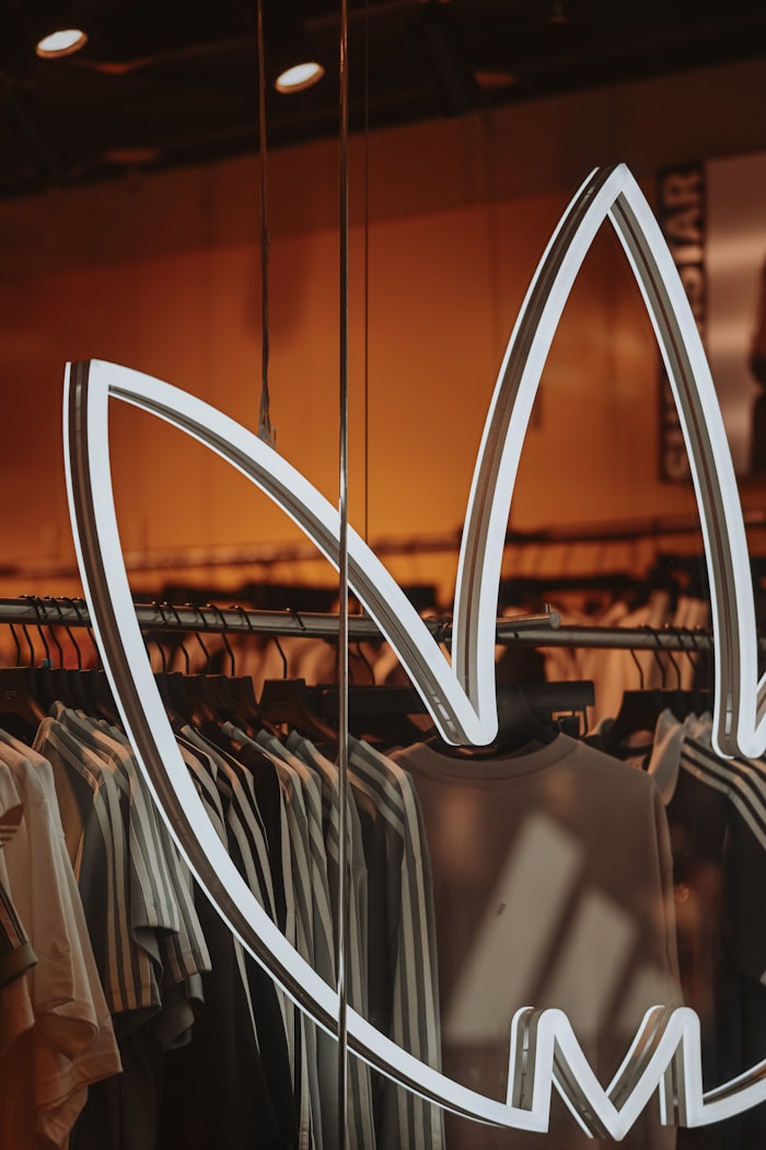 Adidas logo displayed in a clothing store window