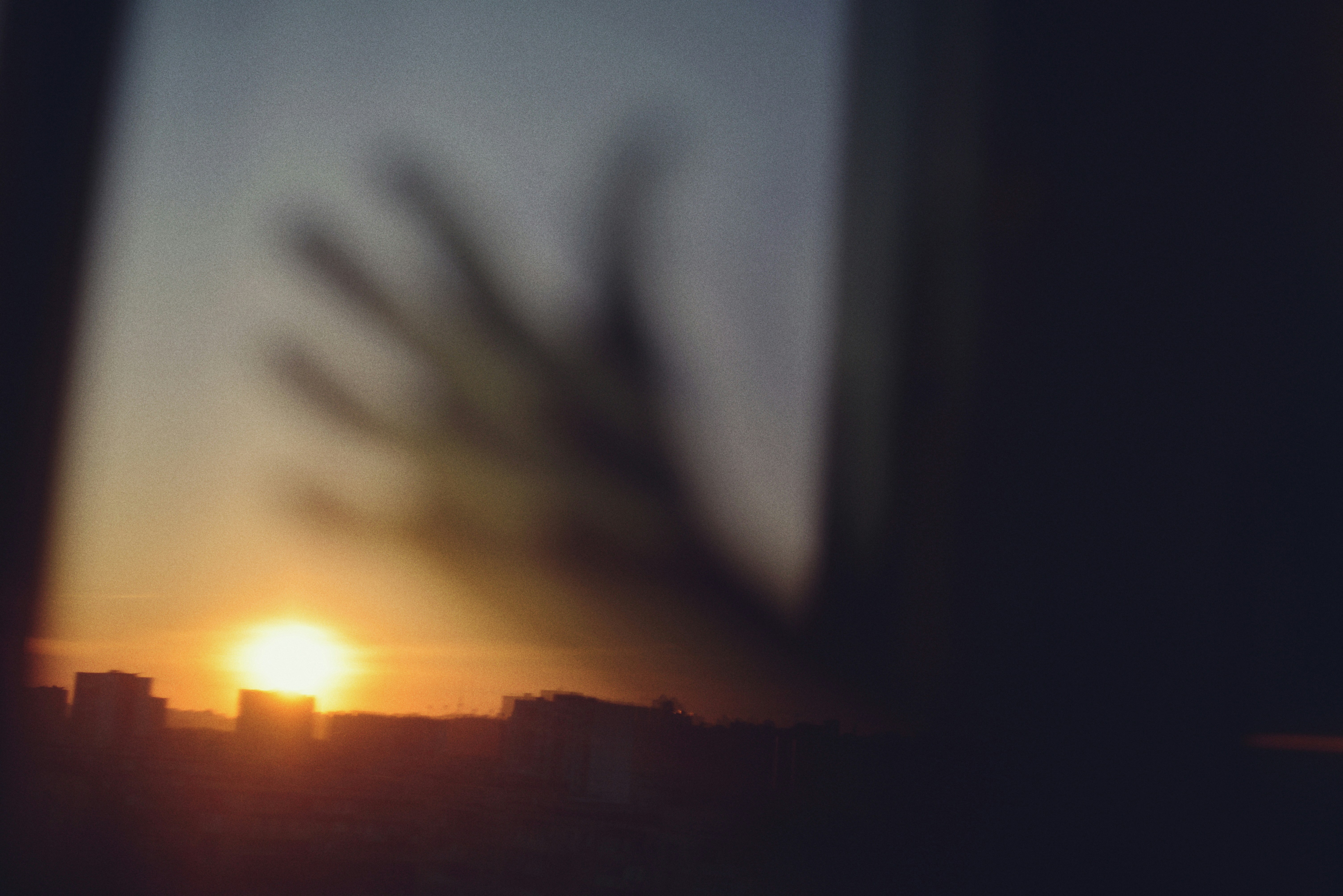 Tramonto sullo skyline della città con silhouette di mani