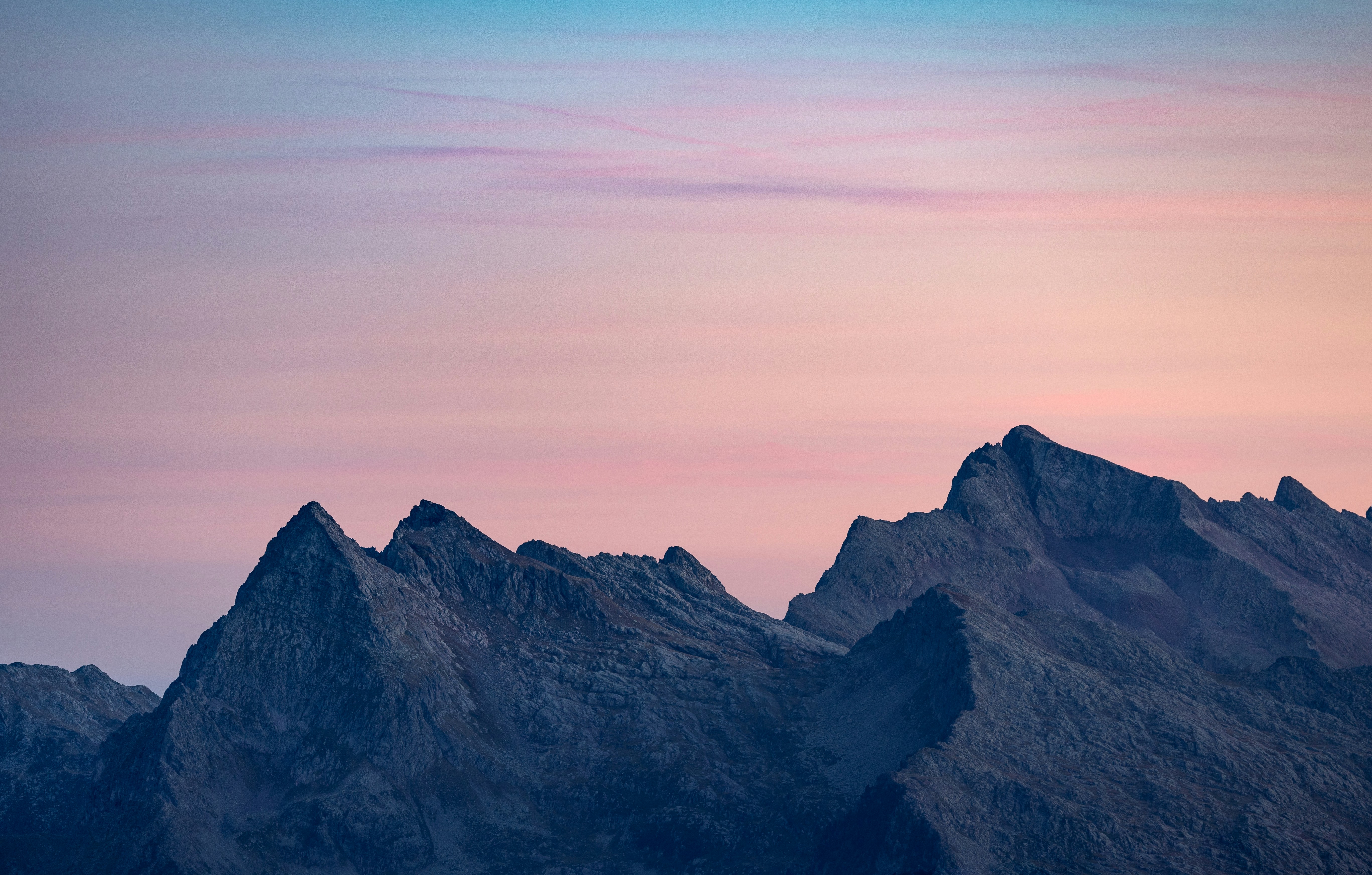 Jagged mountain peaks under a pastel sky