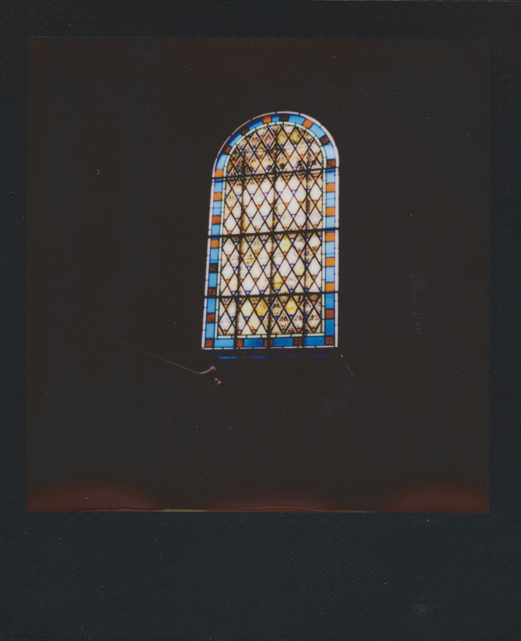 A stained glass window with a diamond pattern