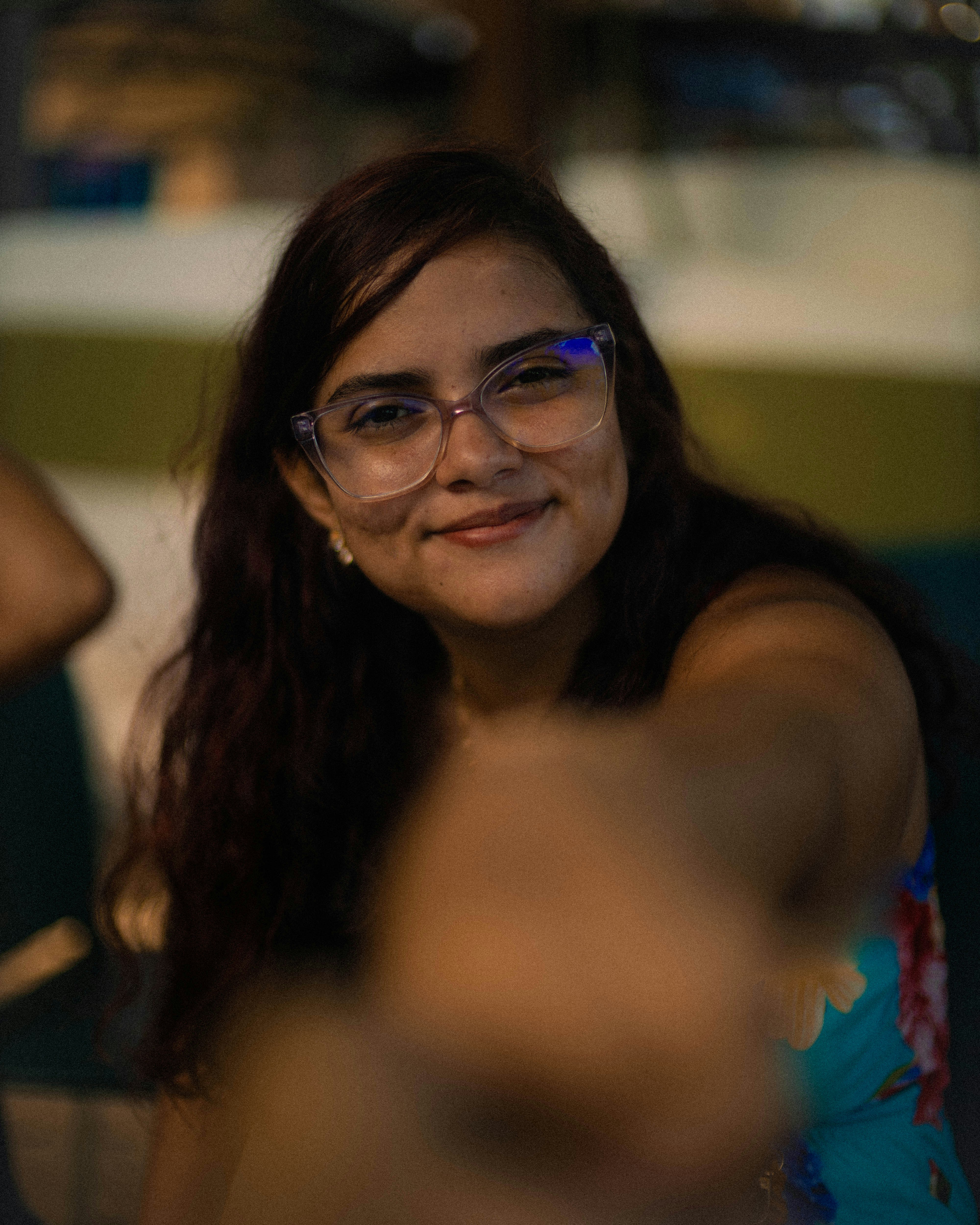 Una joven con gafas sonríe a la cámara.