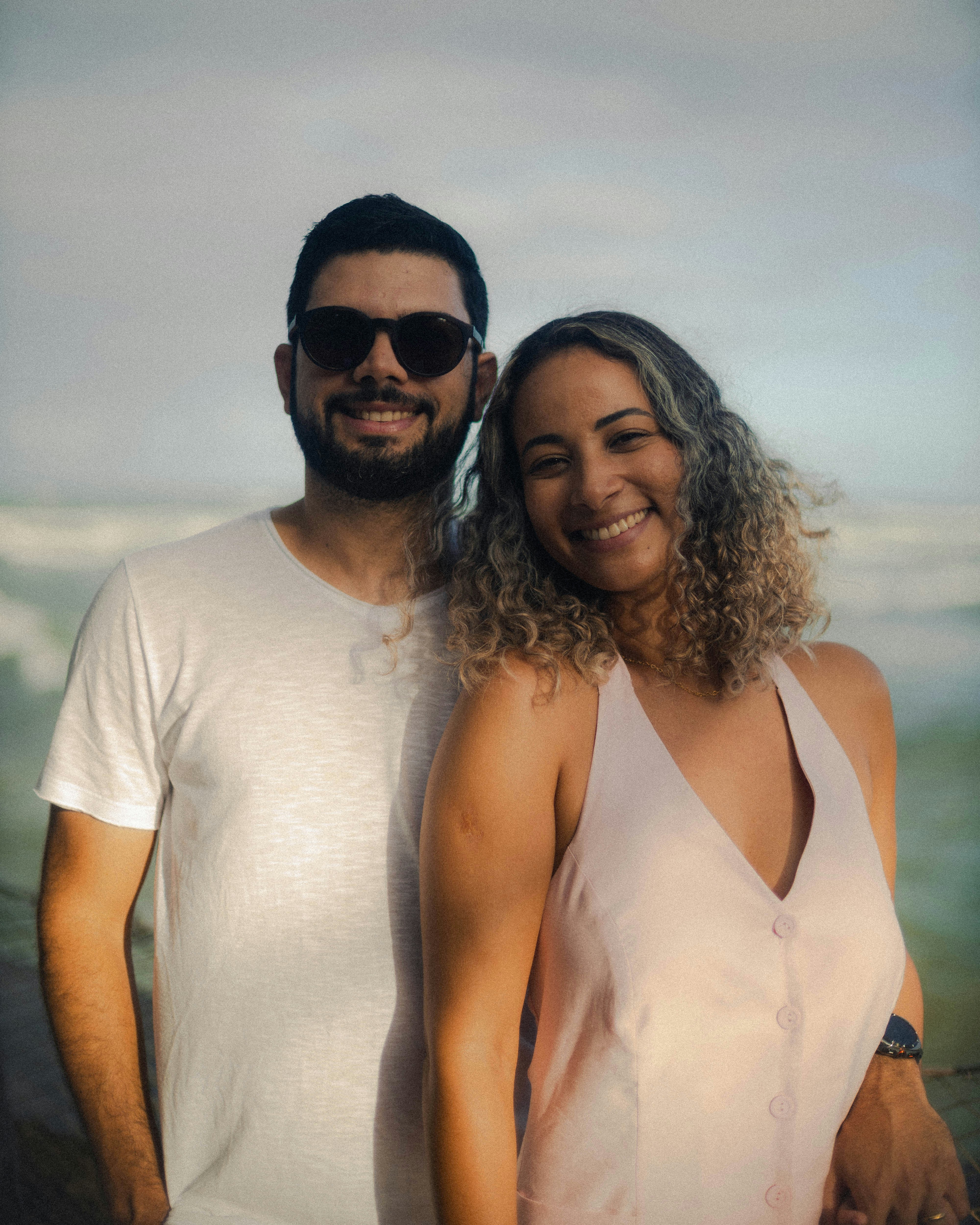 Una pareja sonriente está junta junto al mar.