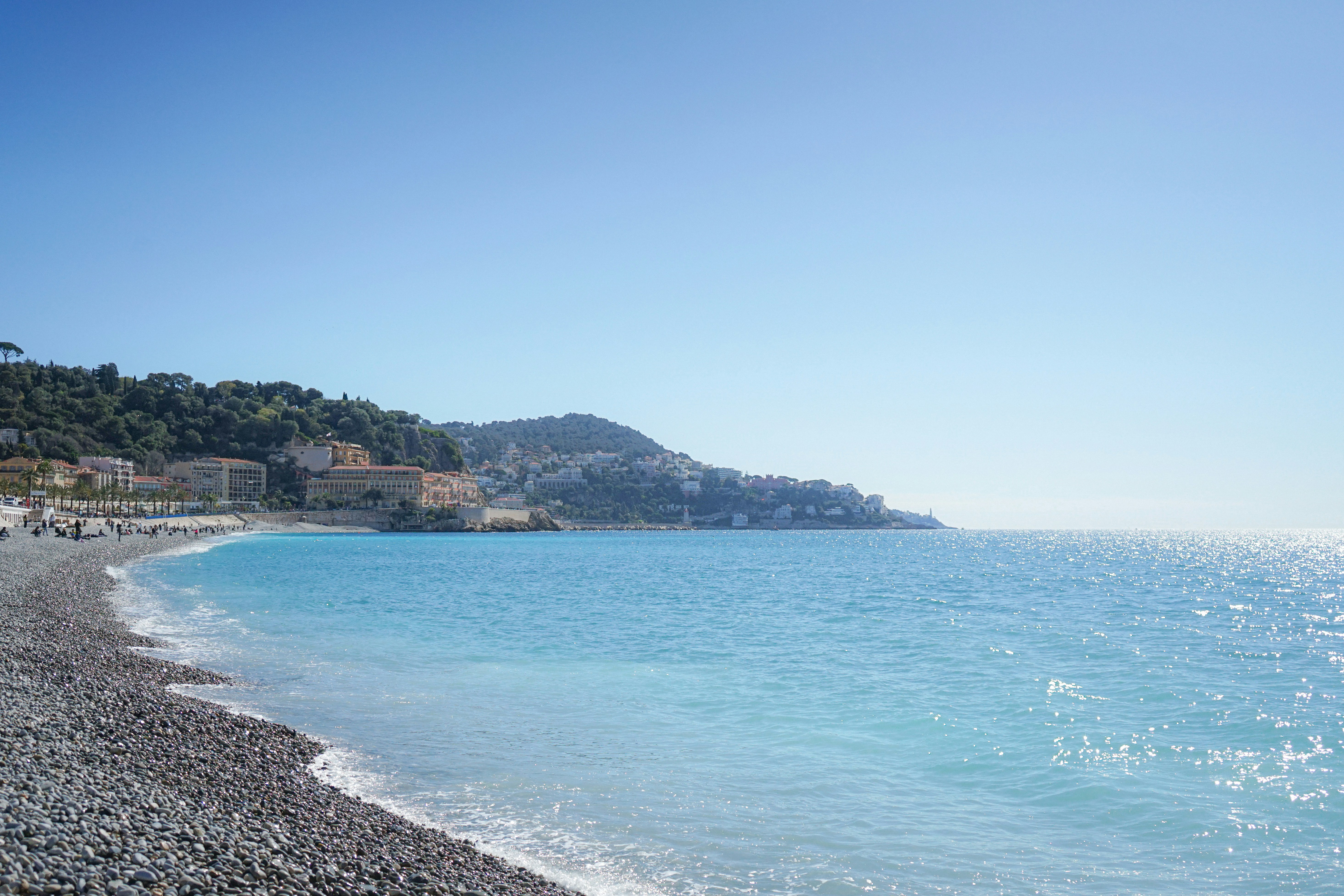 A sunny day at a pebble beach with blue ocean.