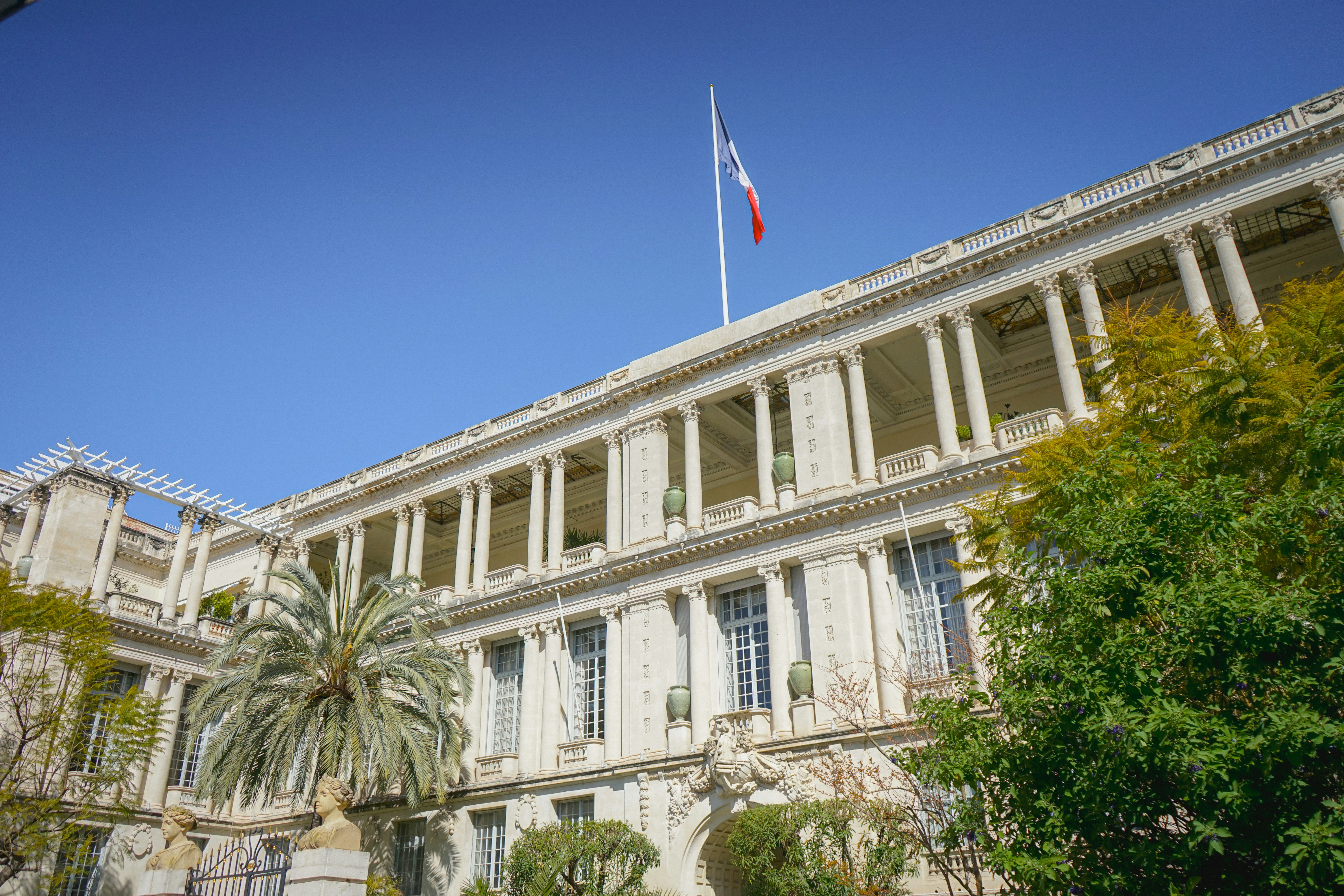 Gran edificio con bandera francesa bajo cielo azul