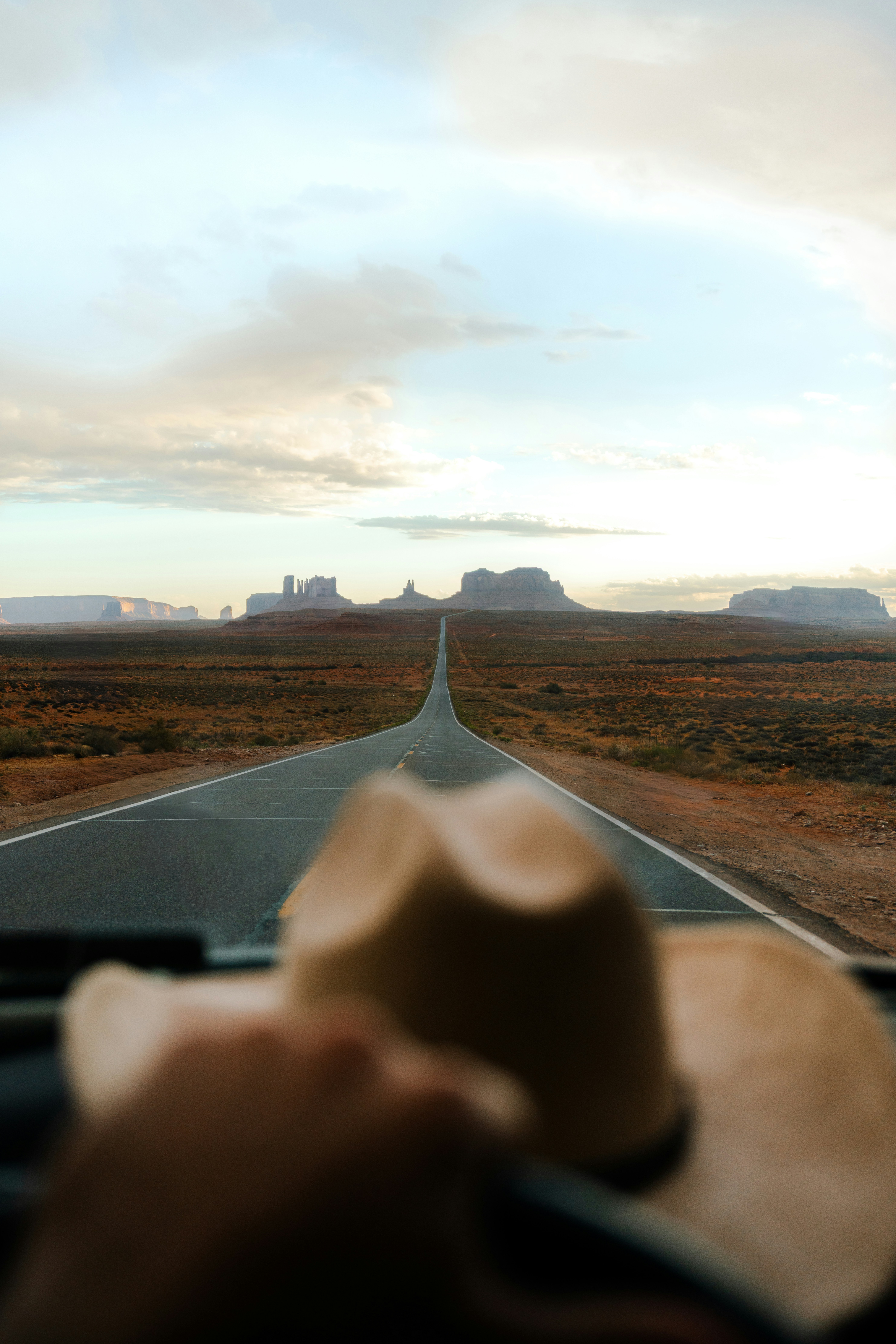 Road through monument valley with cowboy hat