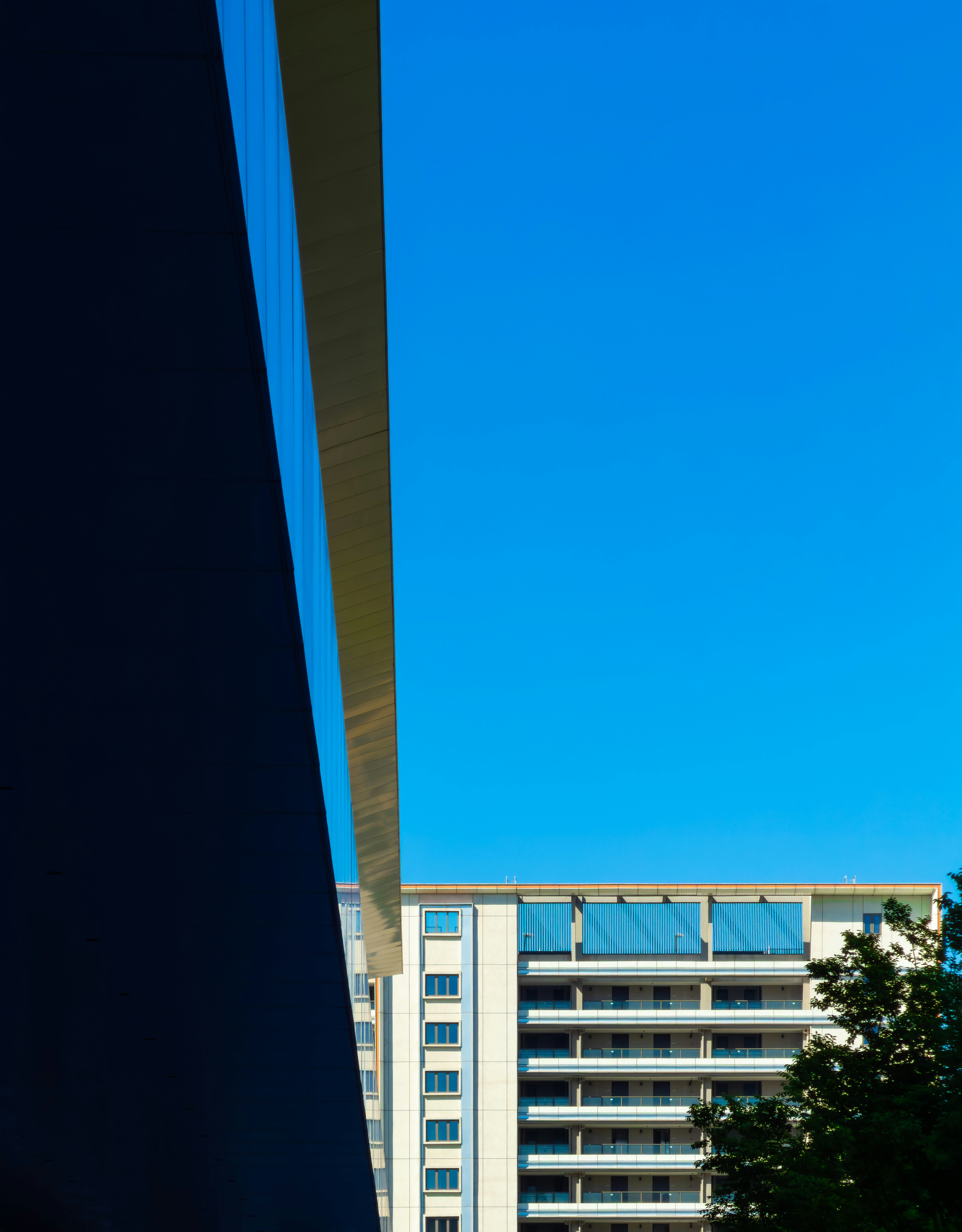 Modern building with balconies against a clear blue sky