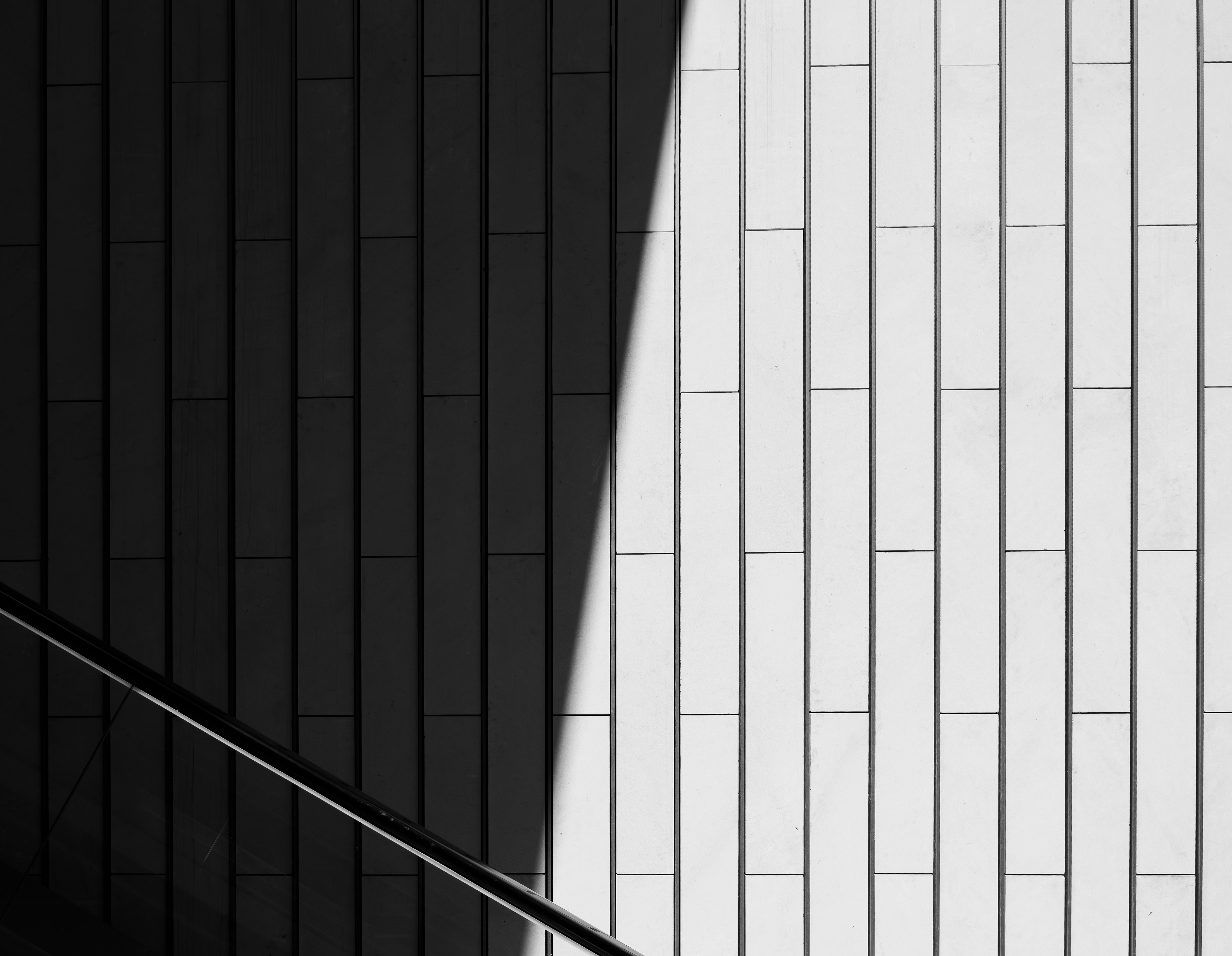 Abstract pattern of light and shadow on building facade.