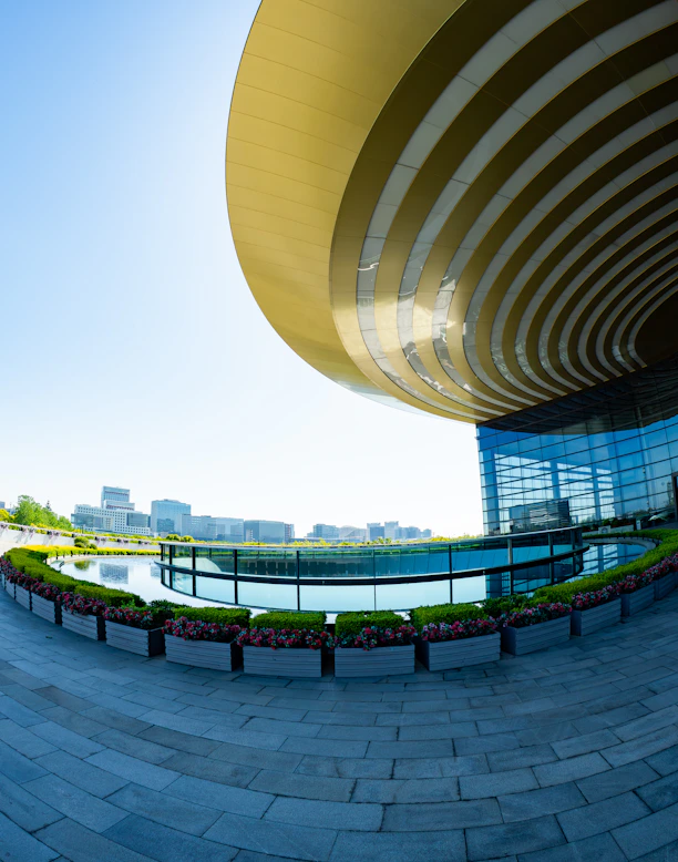 Modern building with a circular reflection pool and gardens