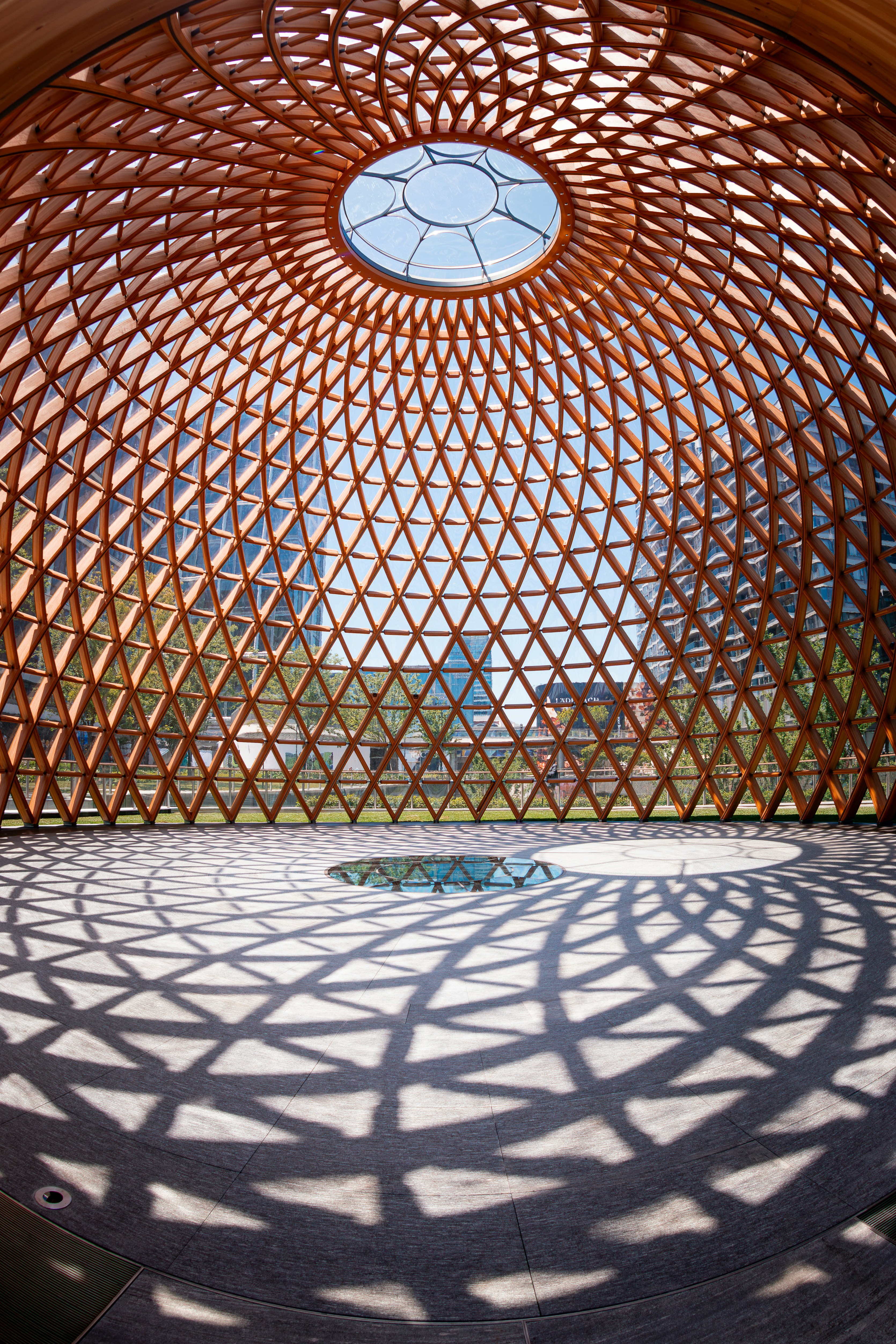Intricate wooden dome ceiling with geometric shadows on floor