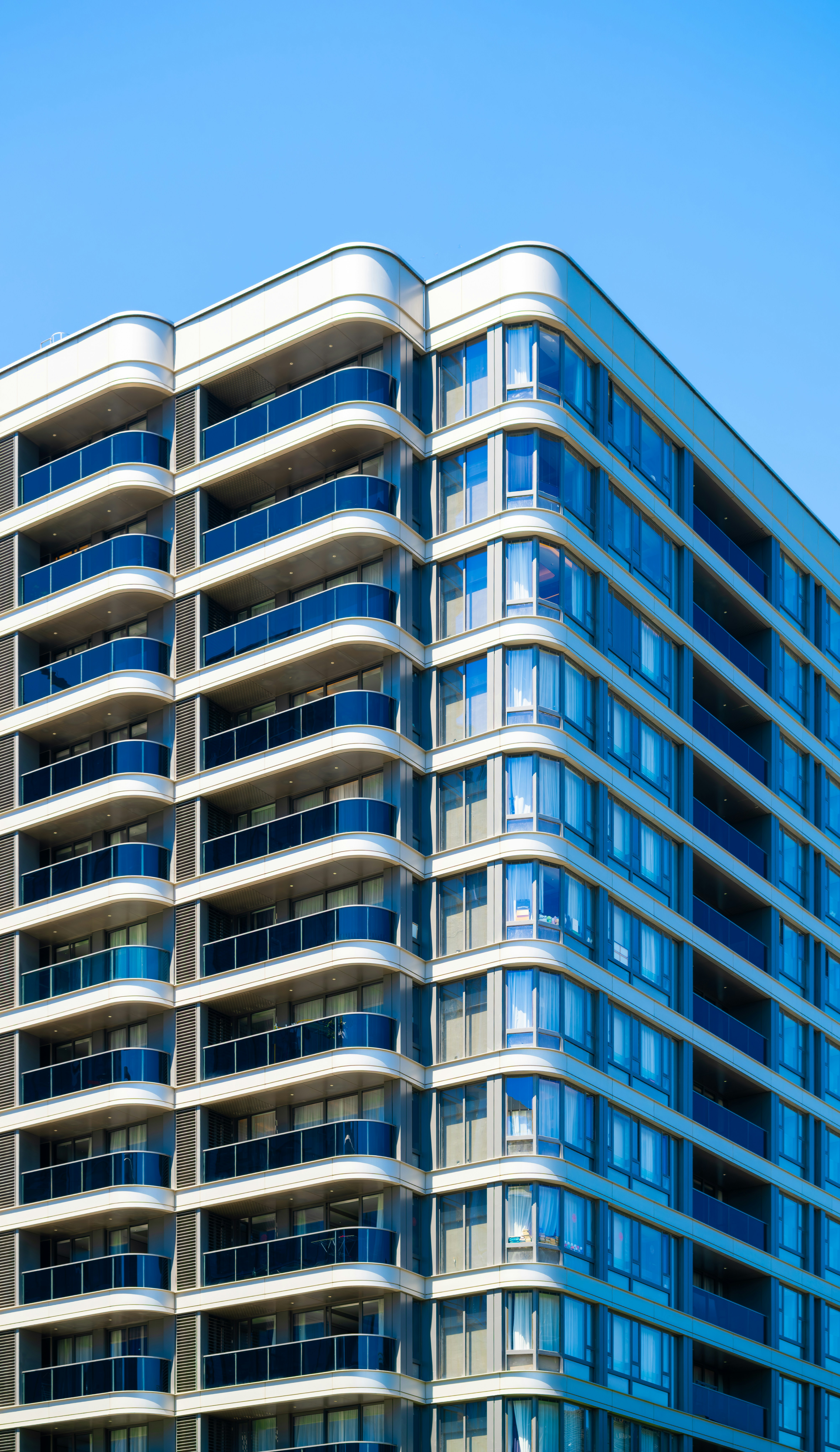 Modern apartment building with balconies against blue sky
