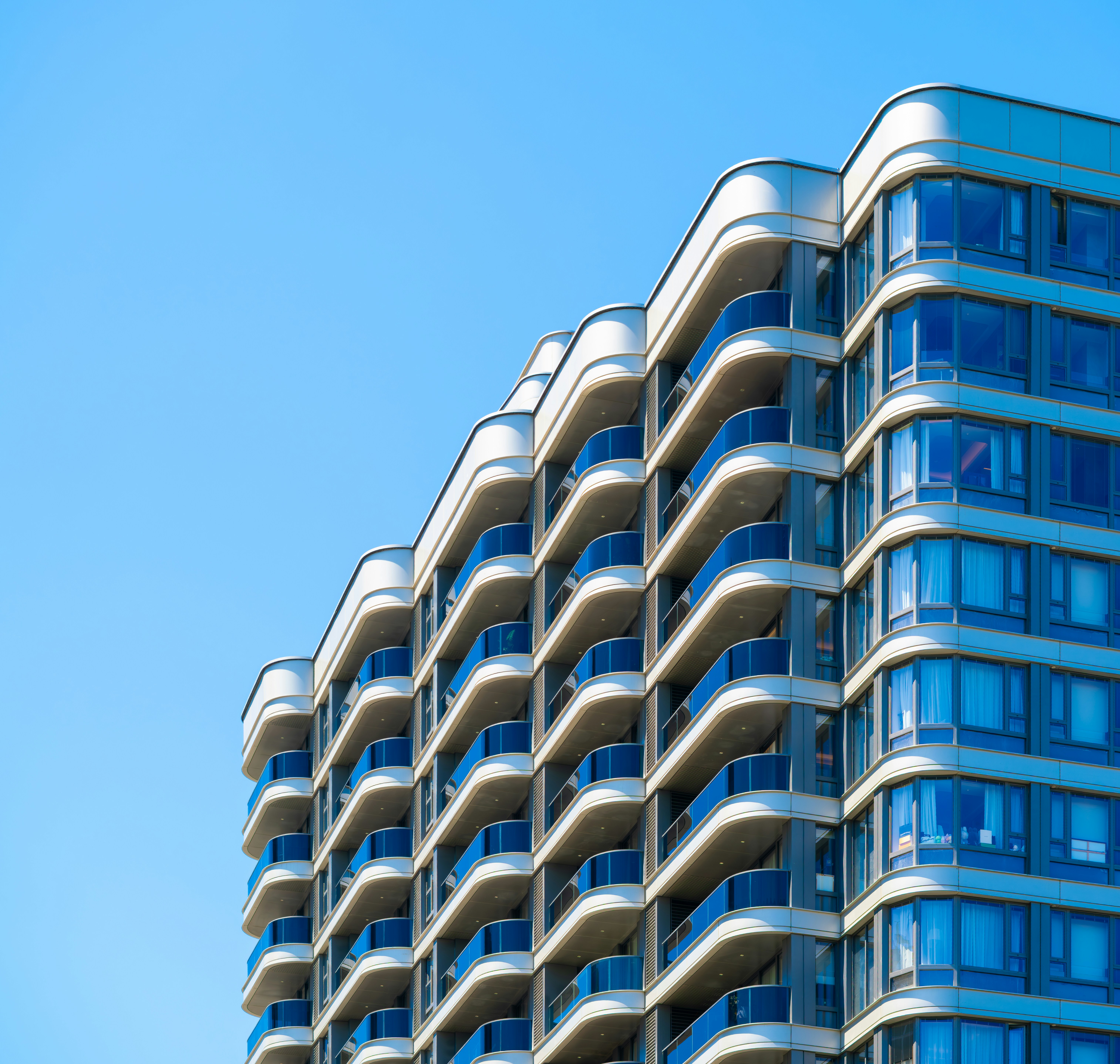 Modern apartment building with balconies against blue sky