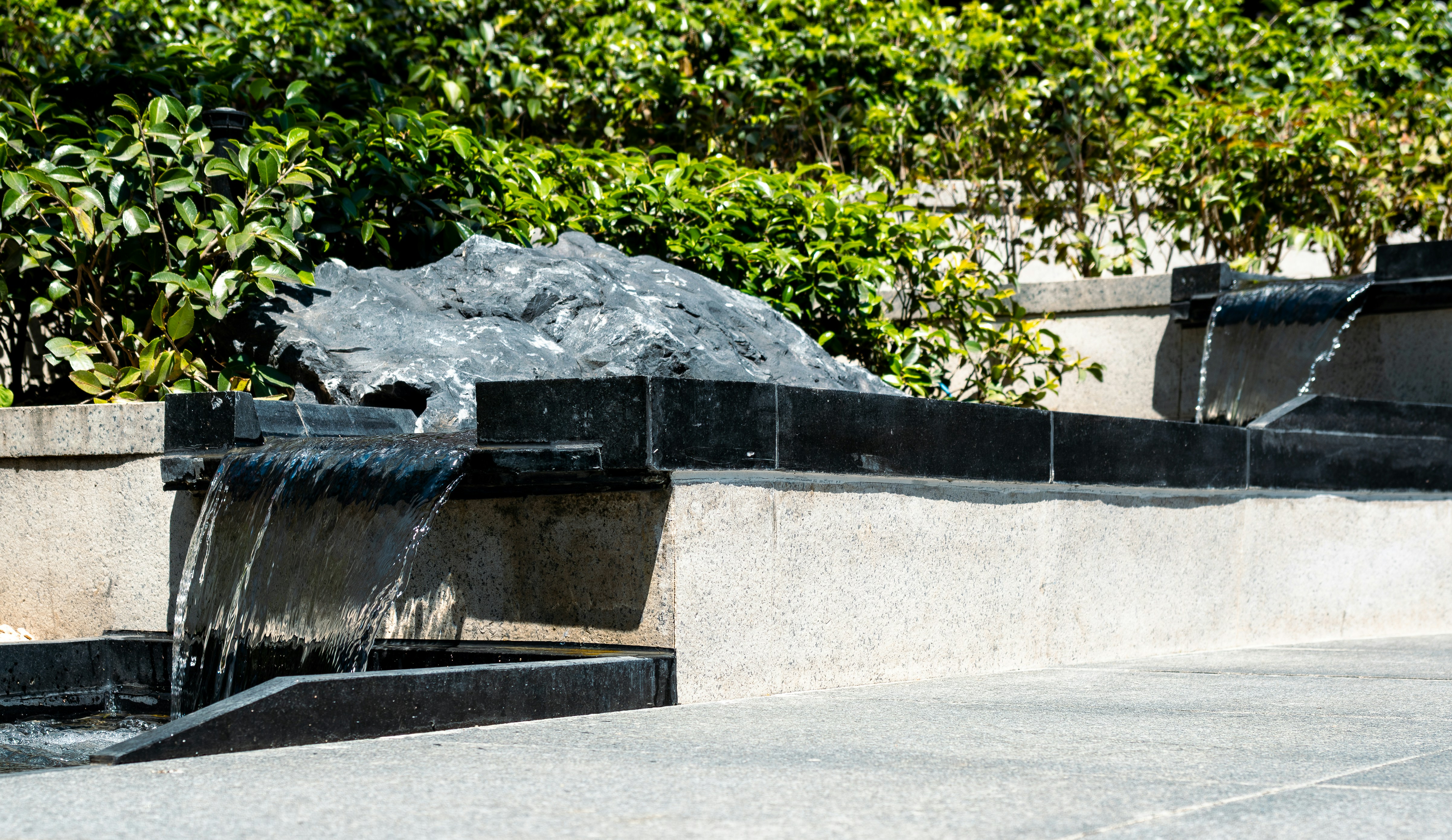 Modern water feature with flowing water and greenery