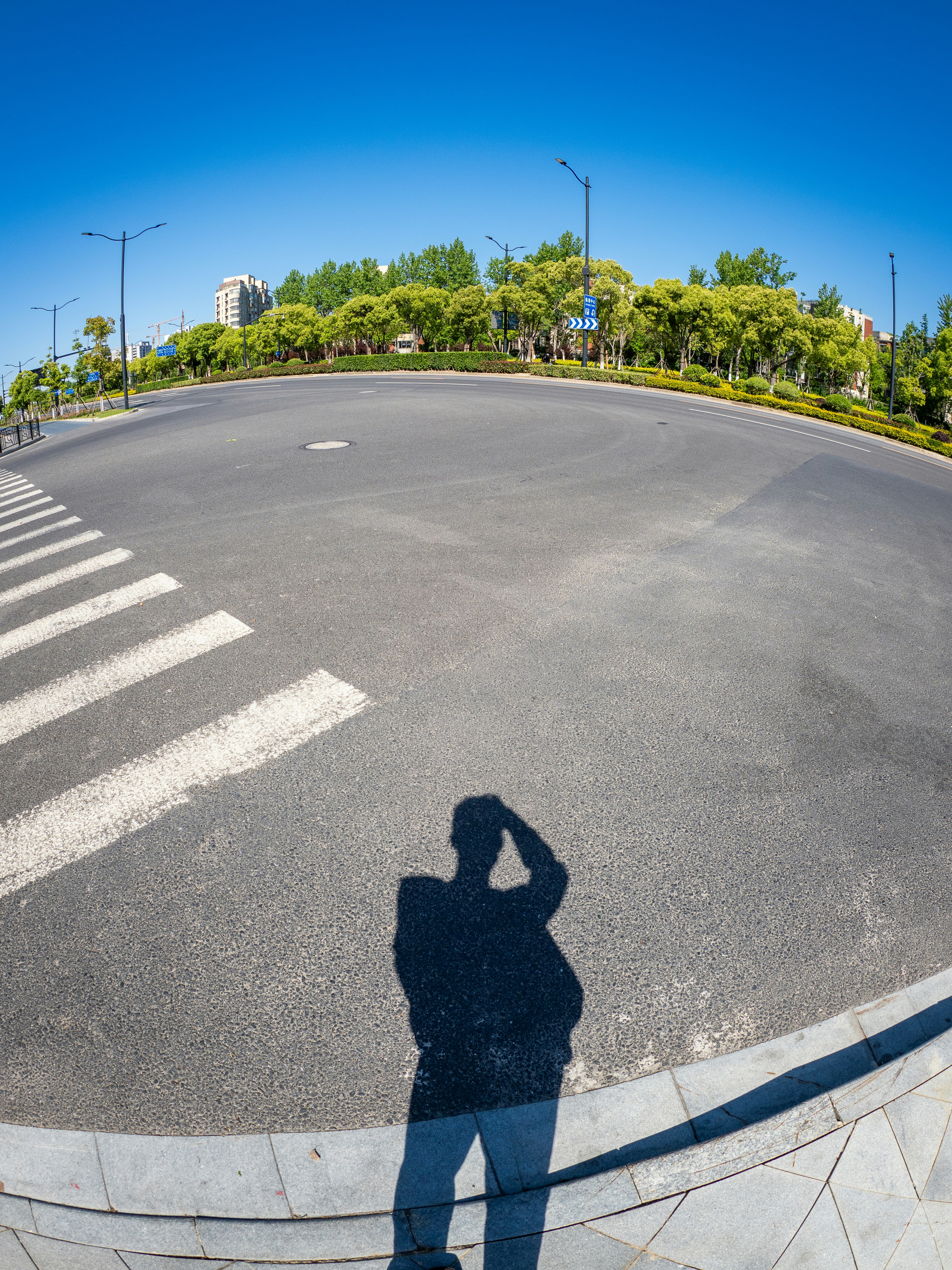 Shadow of a person on an empty asphalt road