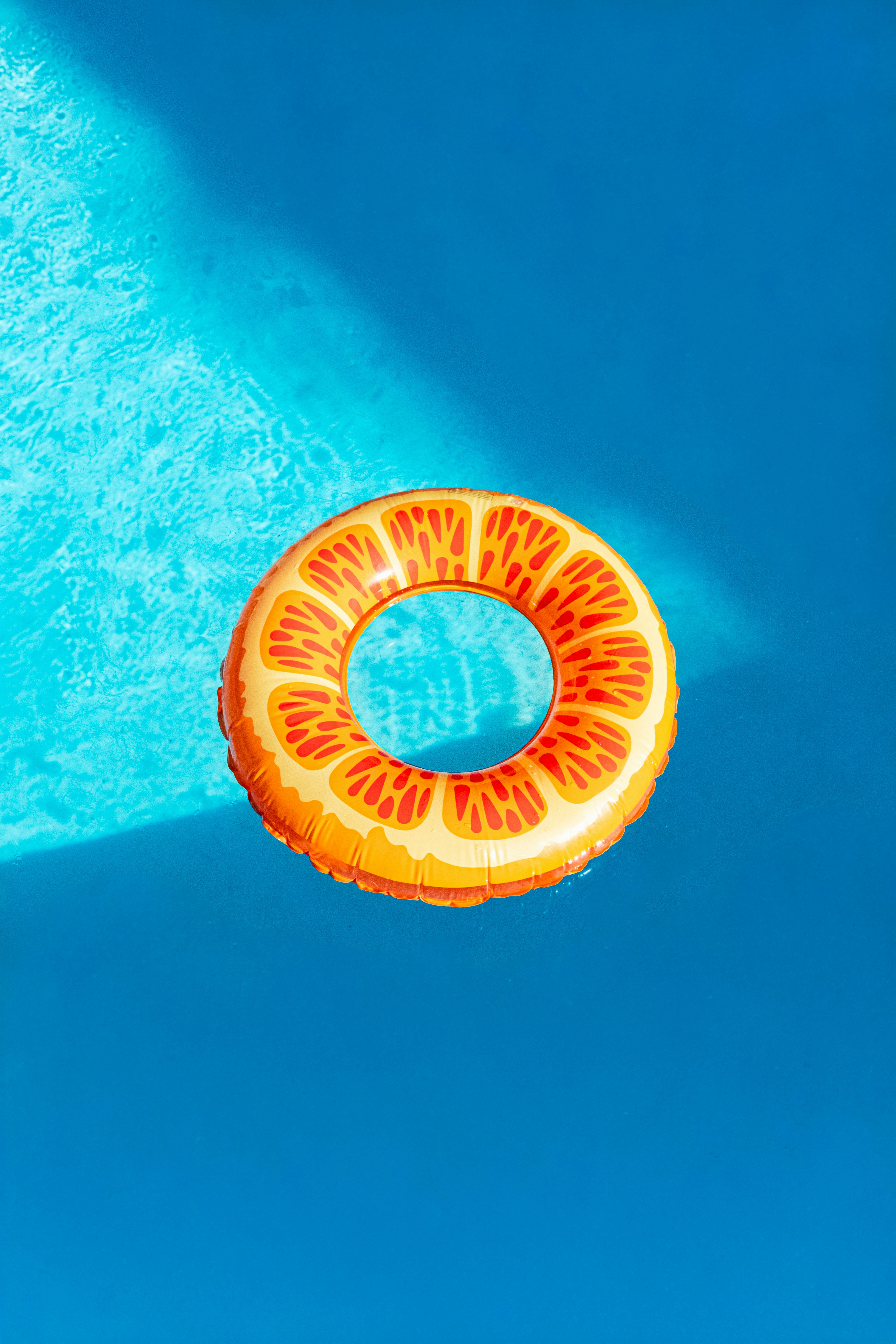 Orange slice inflatable float in a blue swimming pool