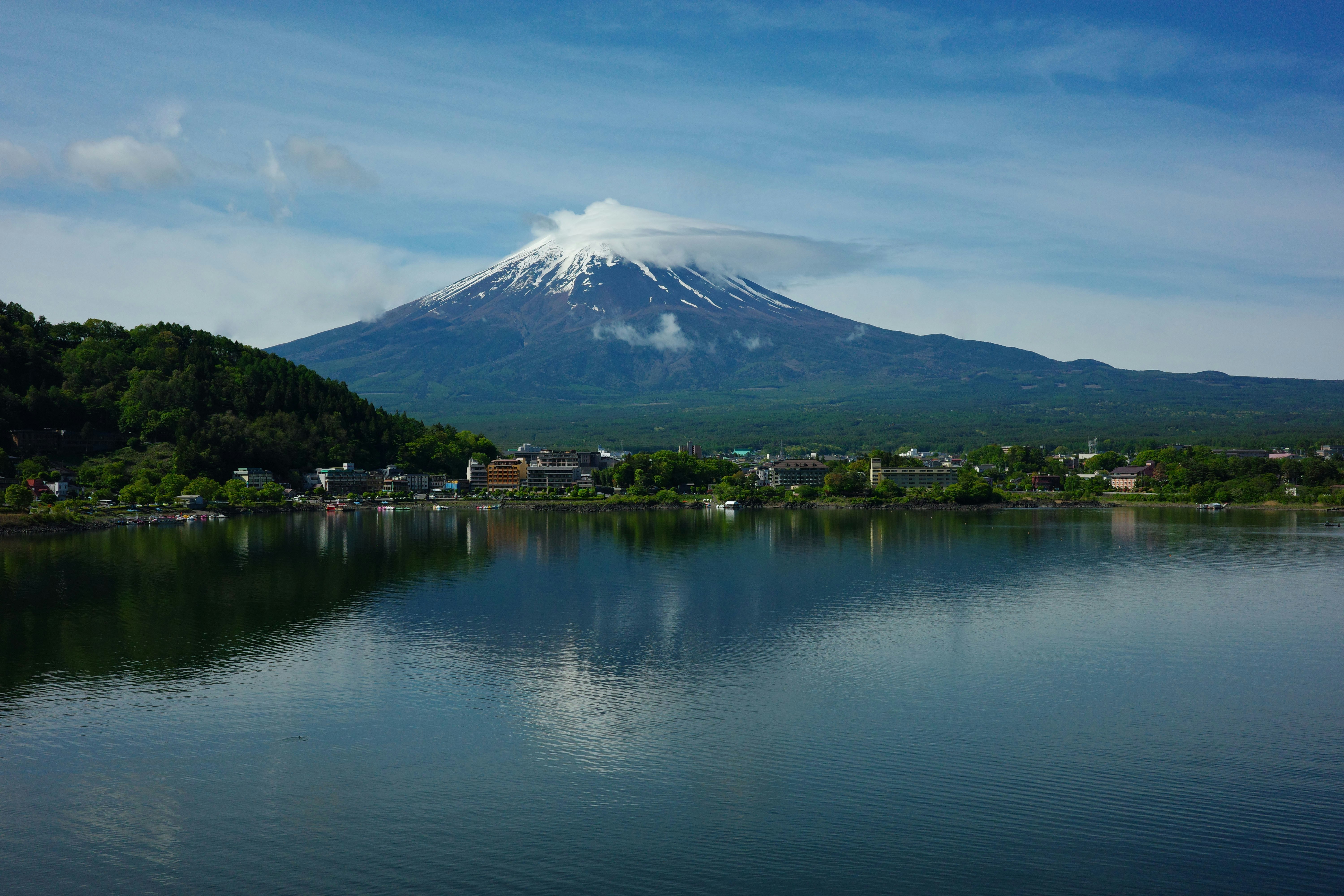 Mount fuji reflected in a calm lake under blue sky