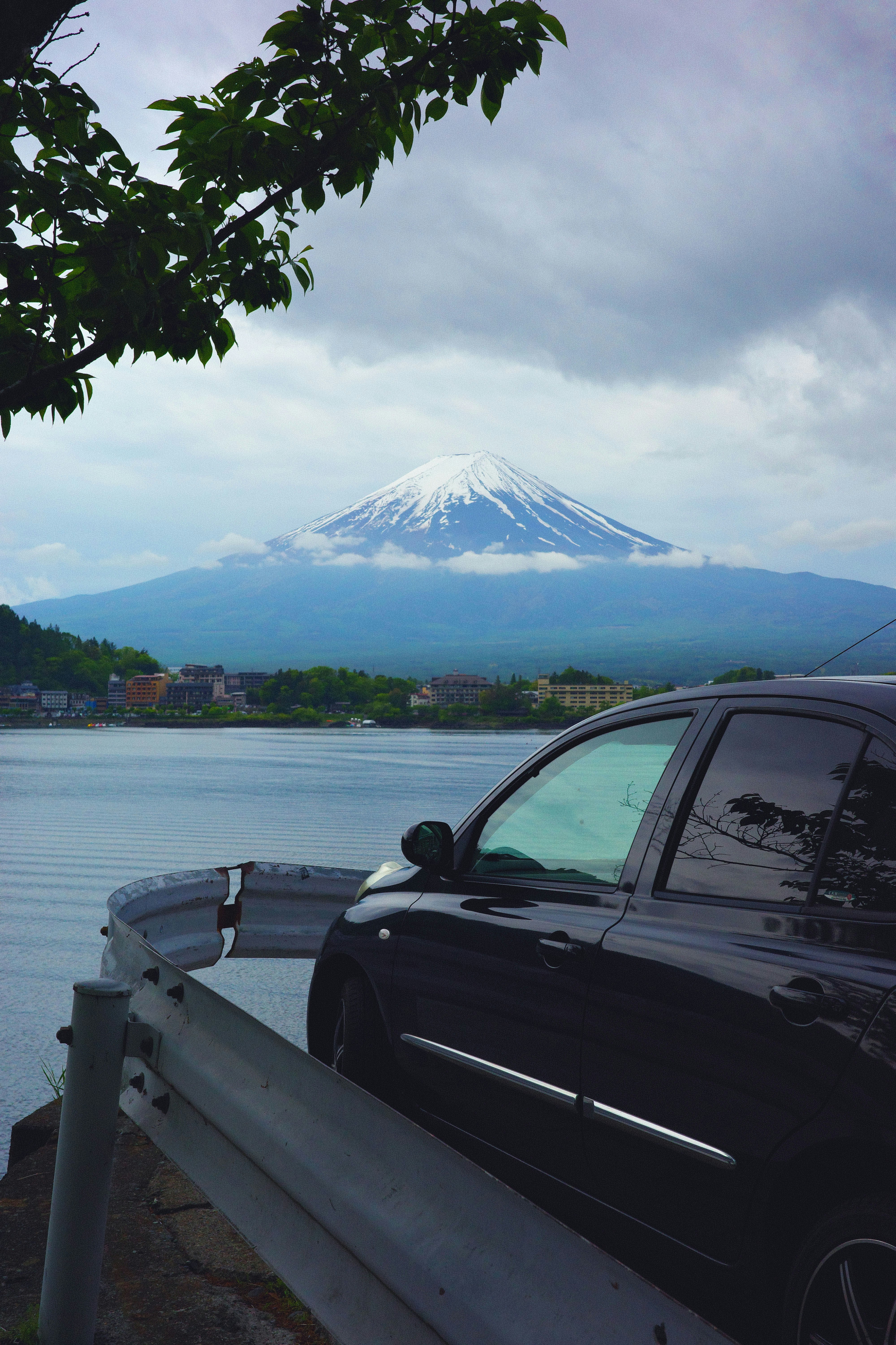 Black car parked by a lake with mount fuji background