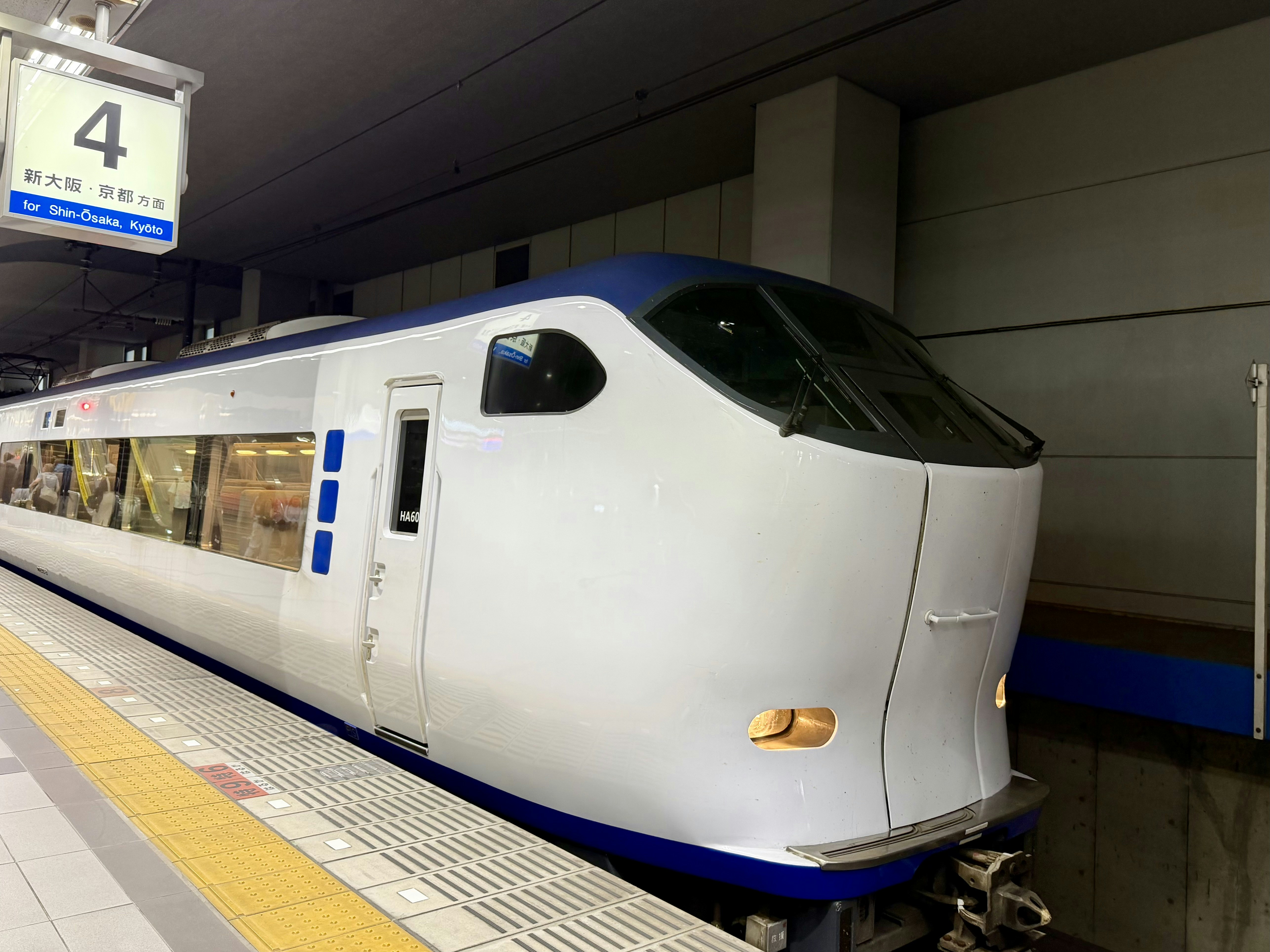 Kereta putih dan biru modern di peron stasiun.