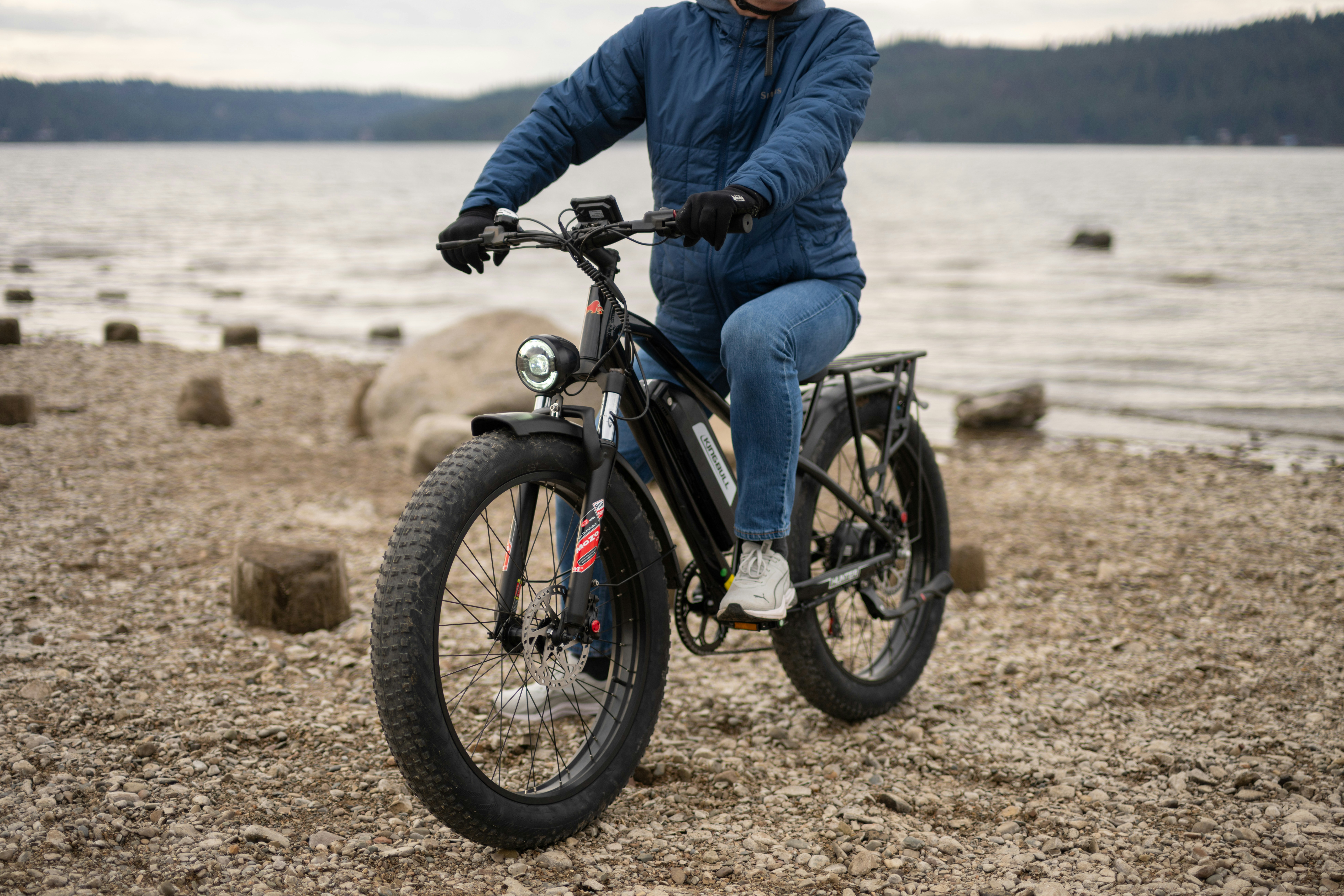 Pessoa andando de bicicleta elétrica perto de um lago