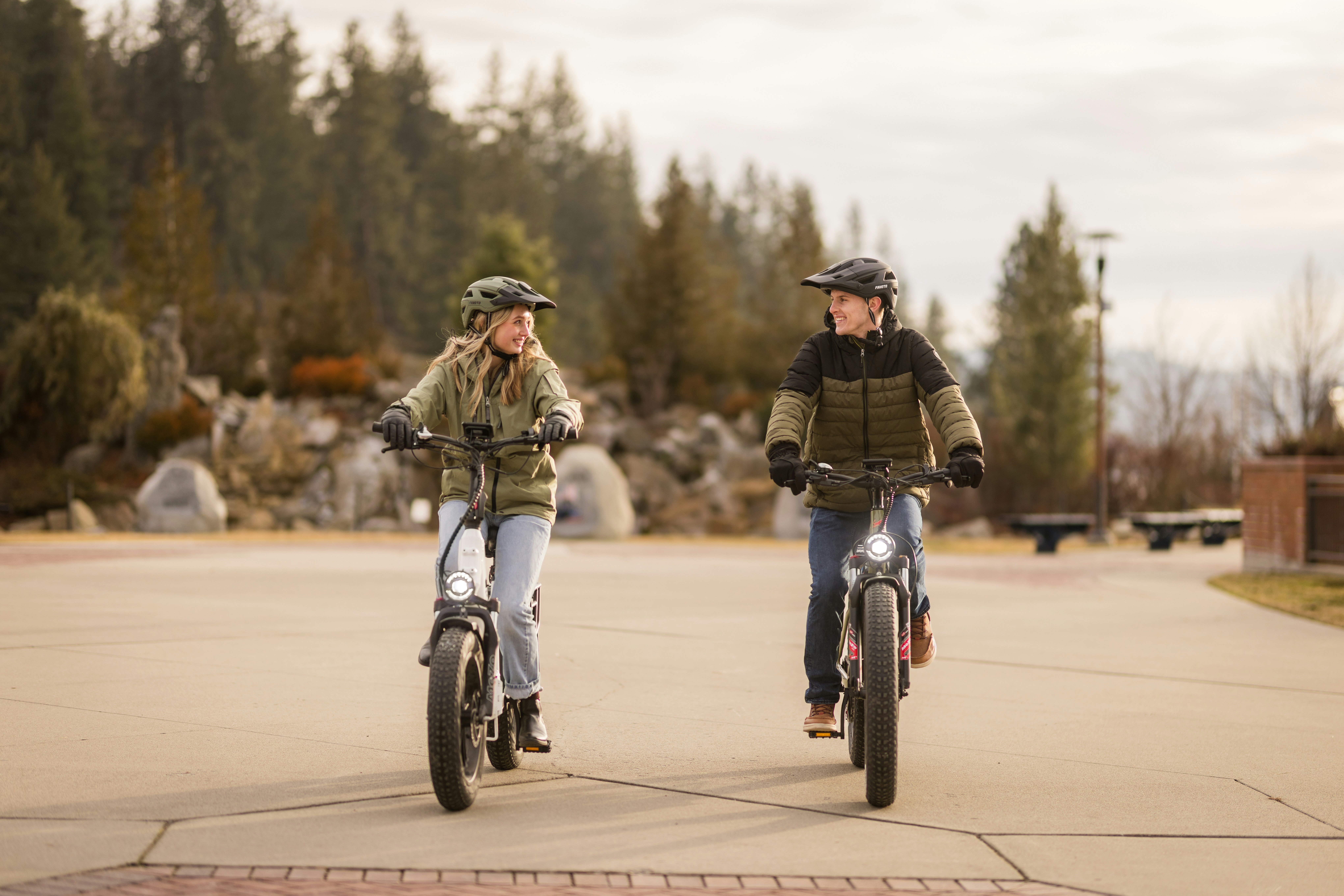 Duas pessoas andando de bicicleta elétrica ao ar livre