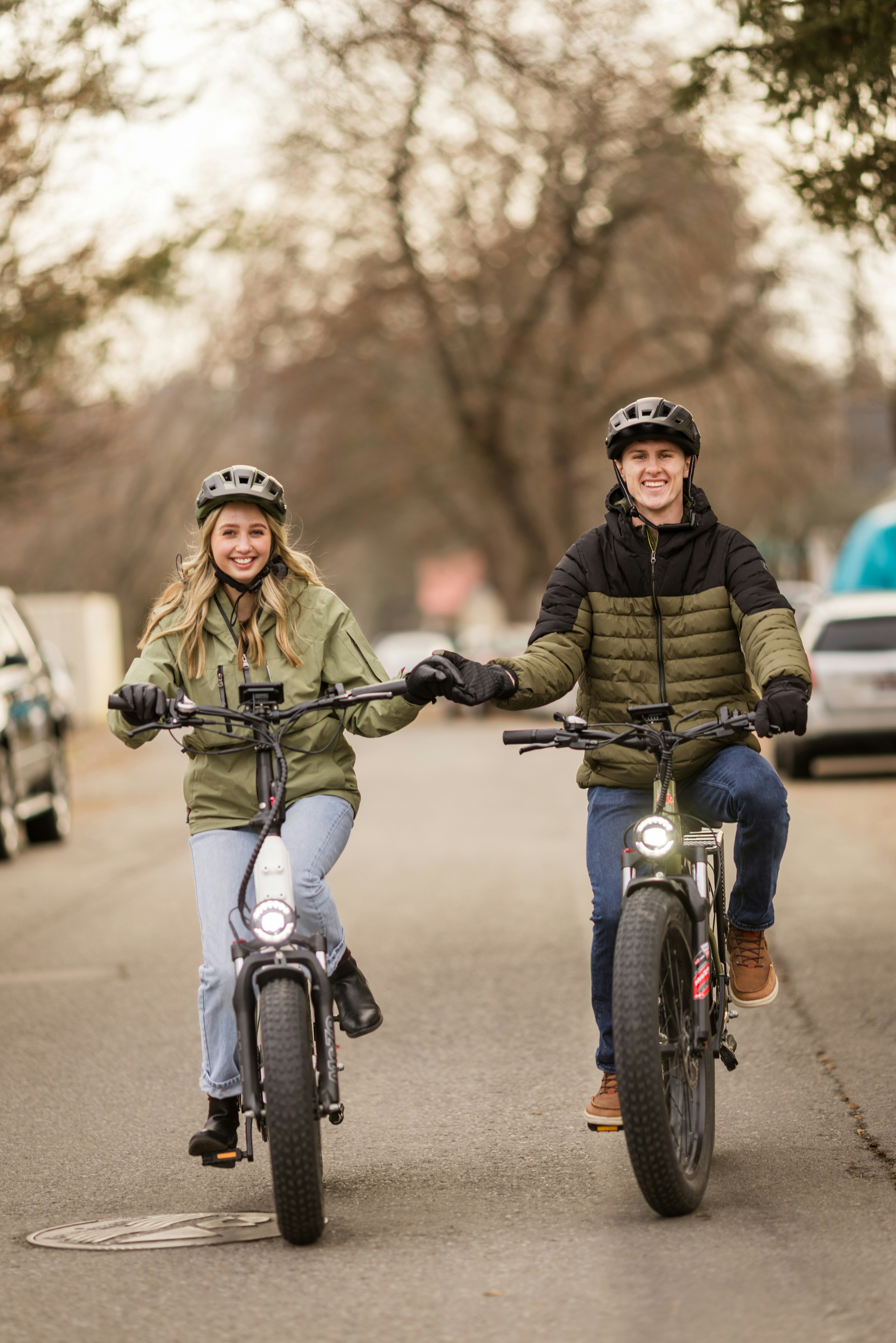 Casal andando de bicicleta elétrica na rua