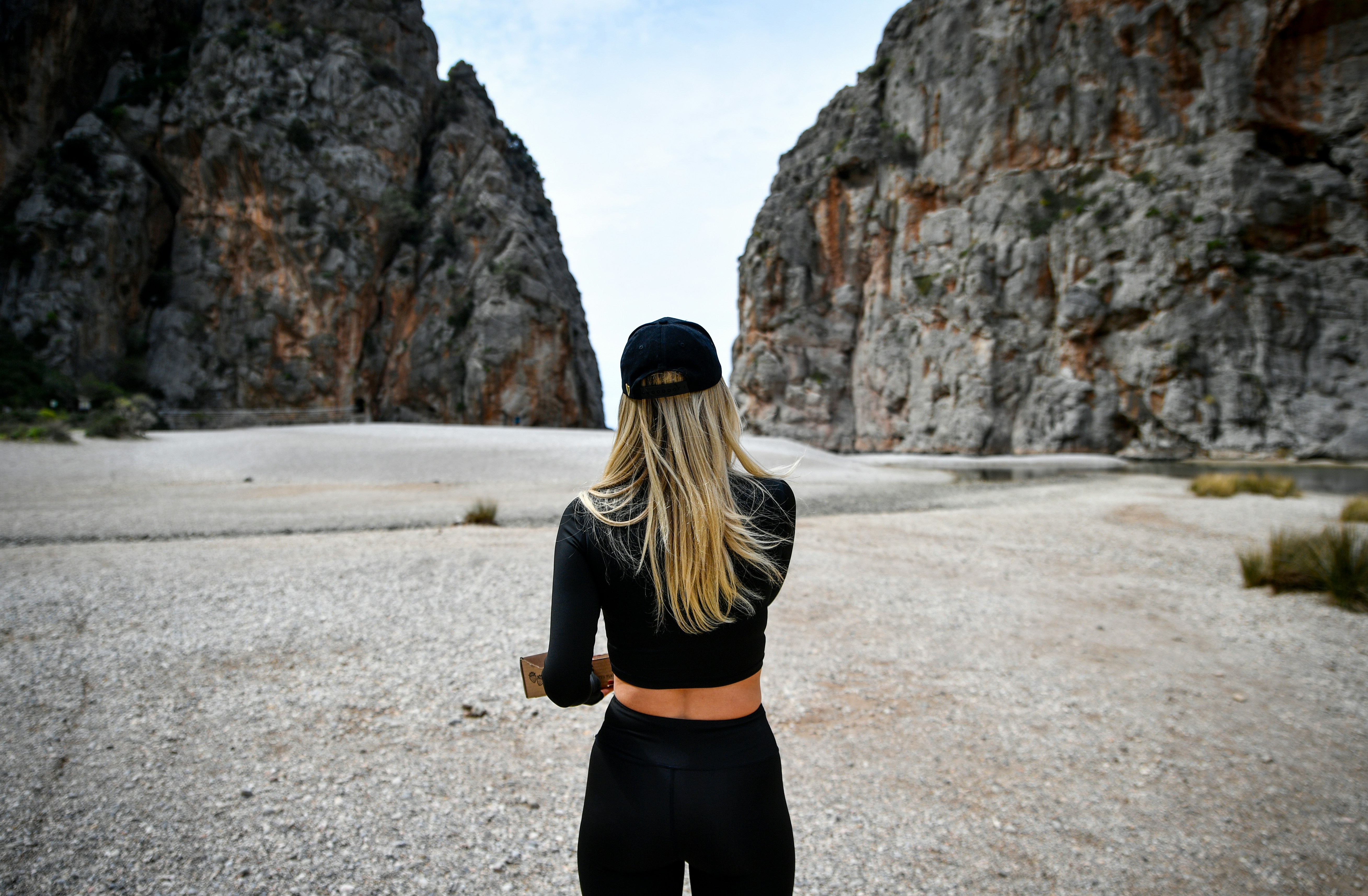 Woman stands between two large rock formations