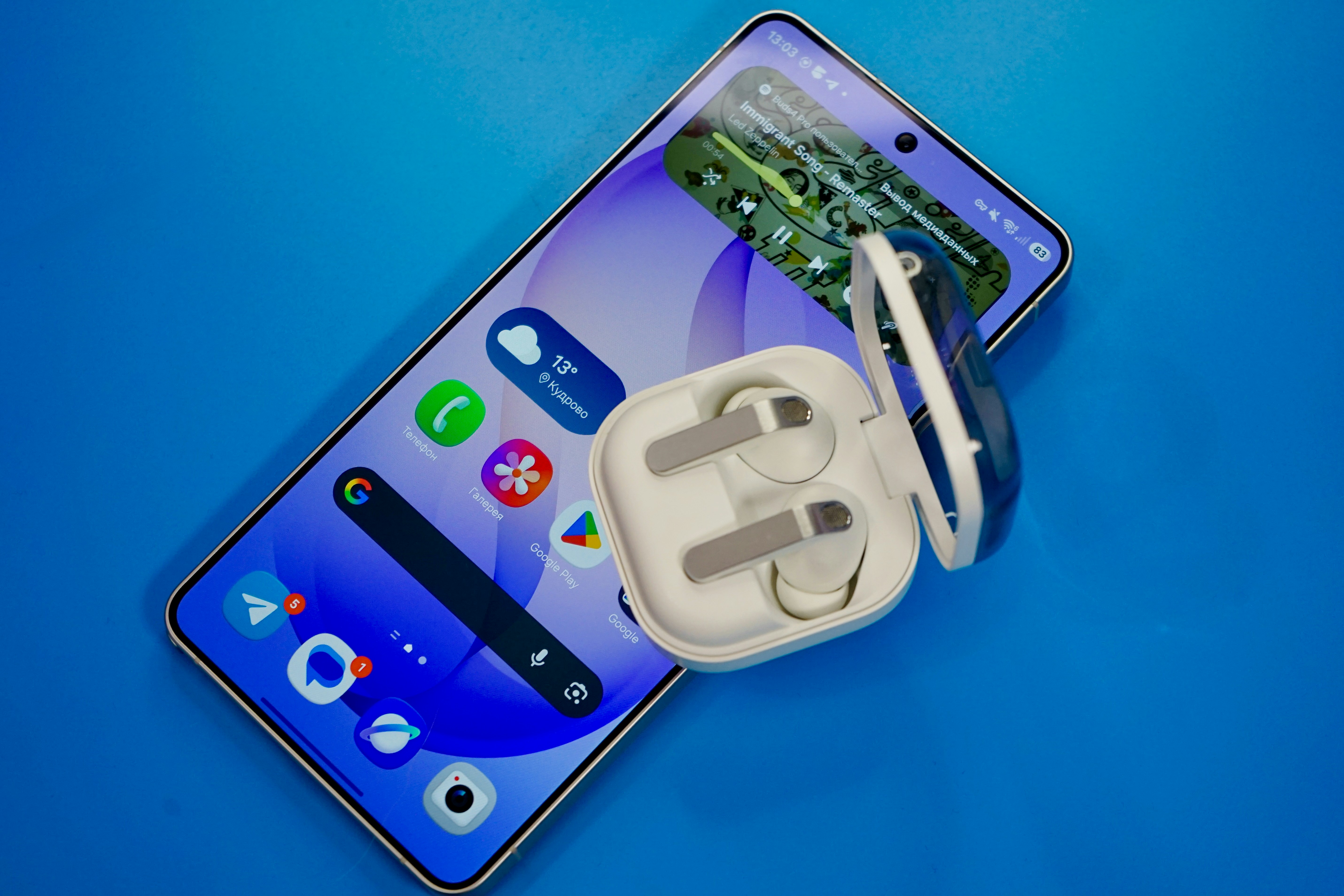 Smartphone avec écouteurs sans fil sur fond bleu