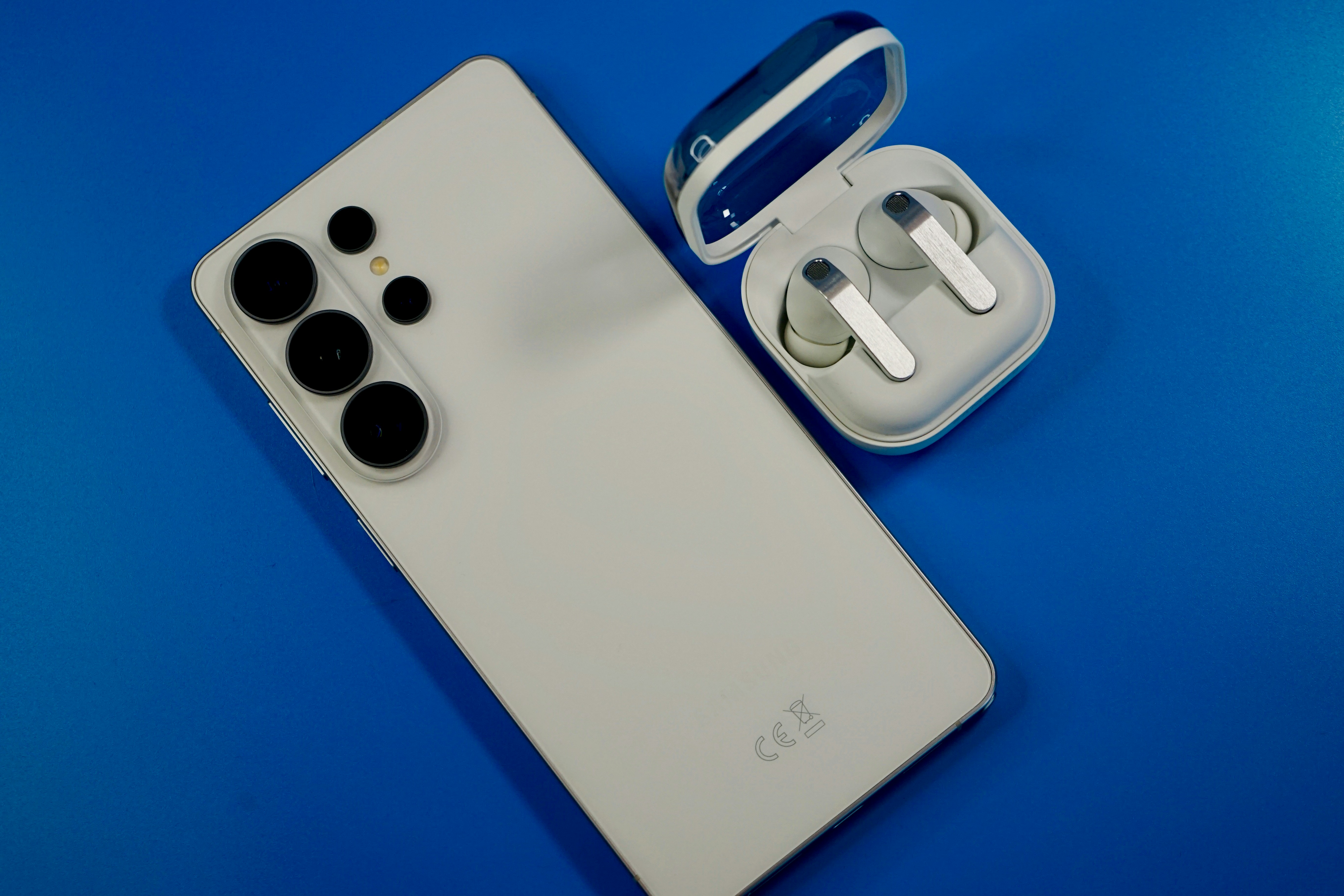 Smartphone blanc et écouteurs sans fil sur fond bleu
