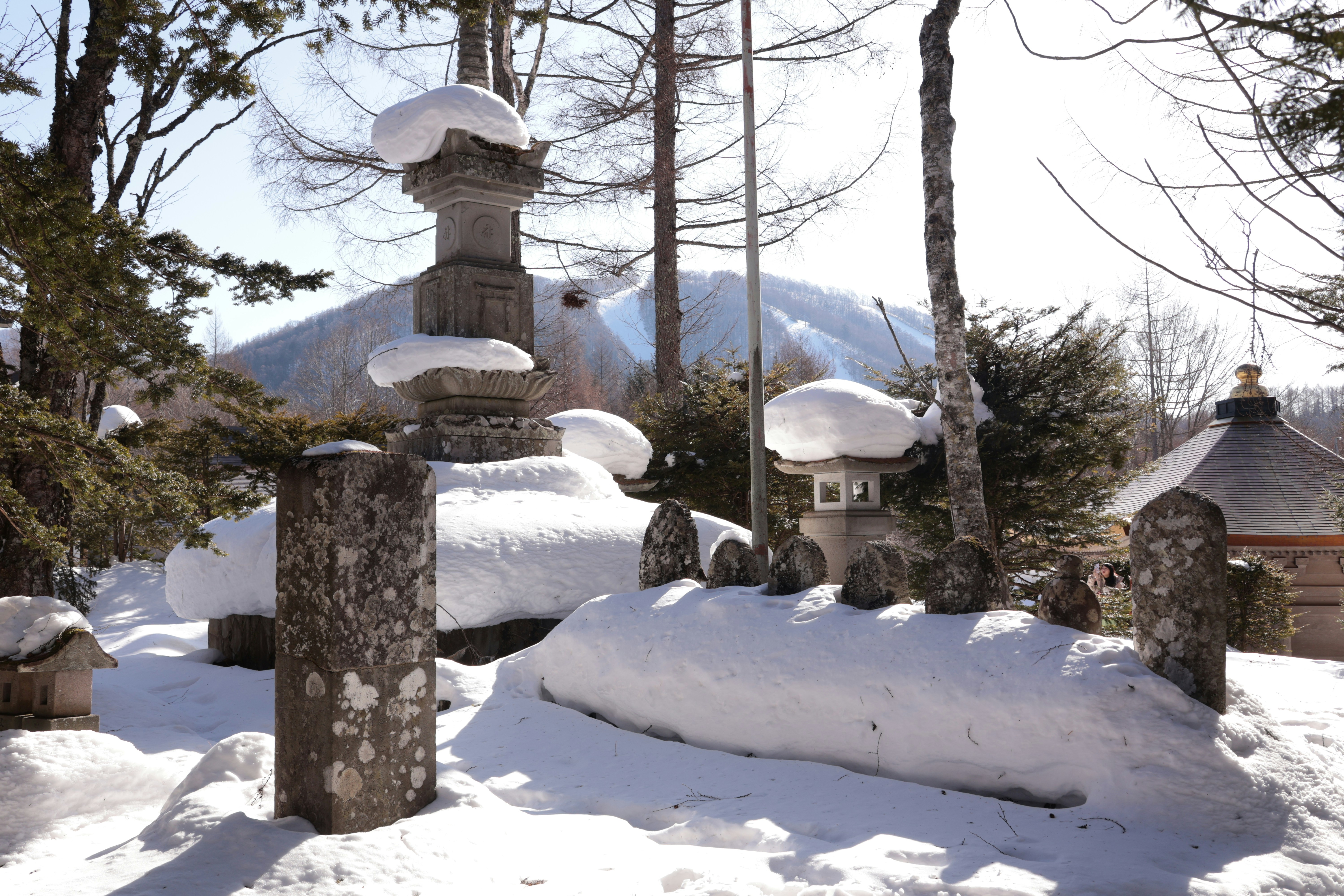 Stone lanterns and monuments covered in snow