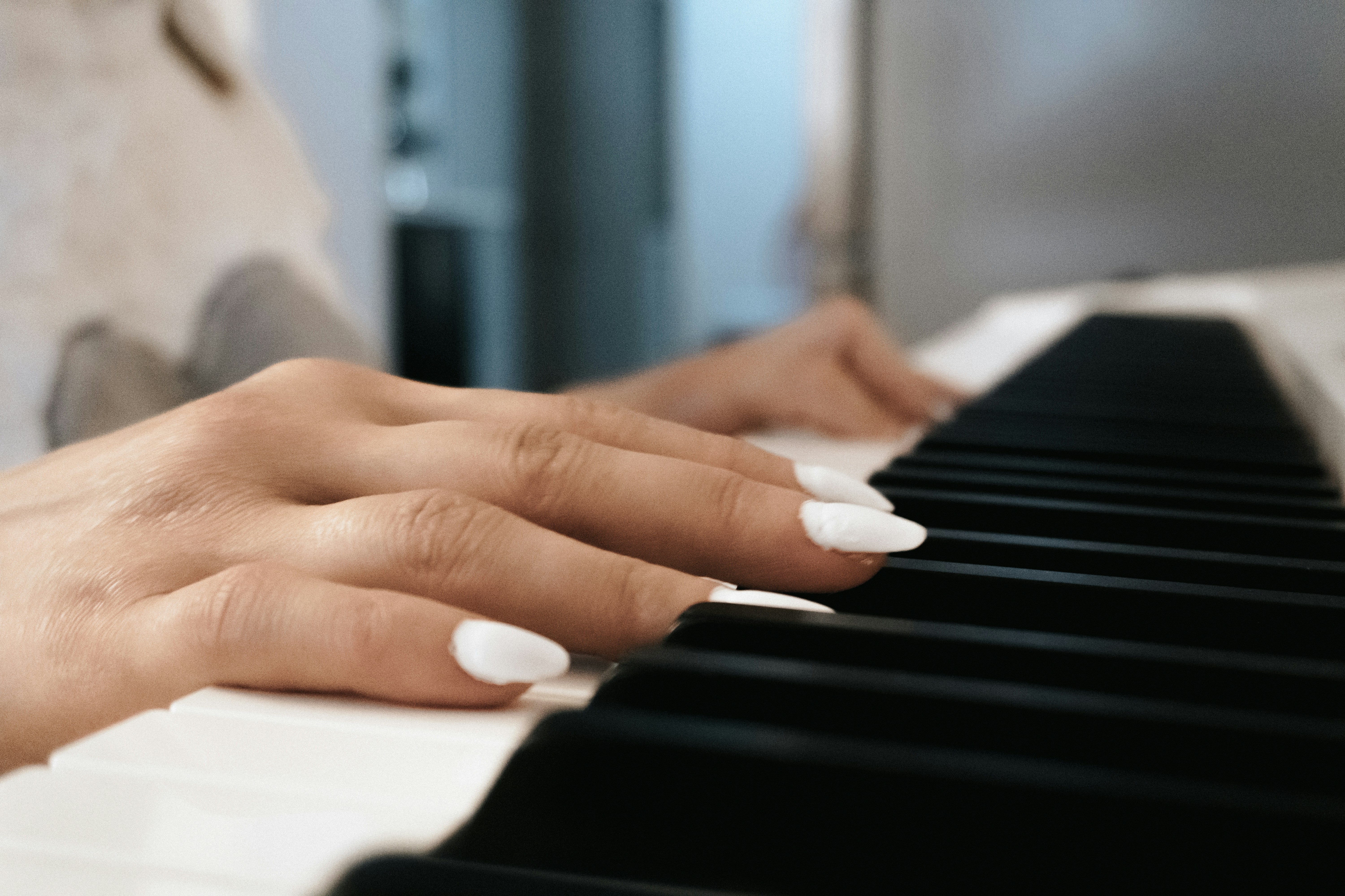 Tangan wanita memainkan keyboard piano
