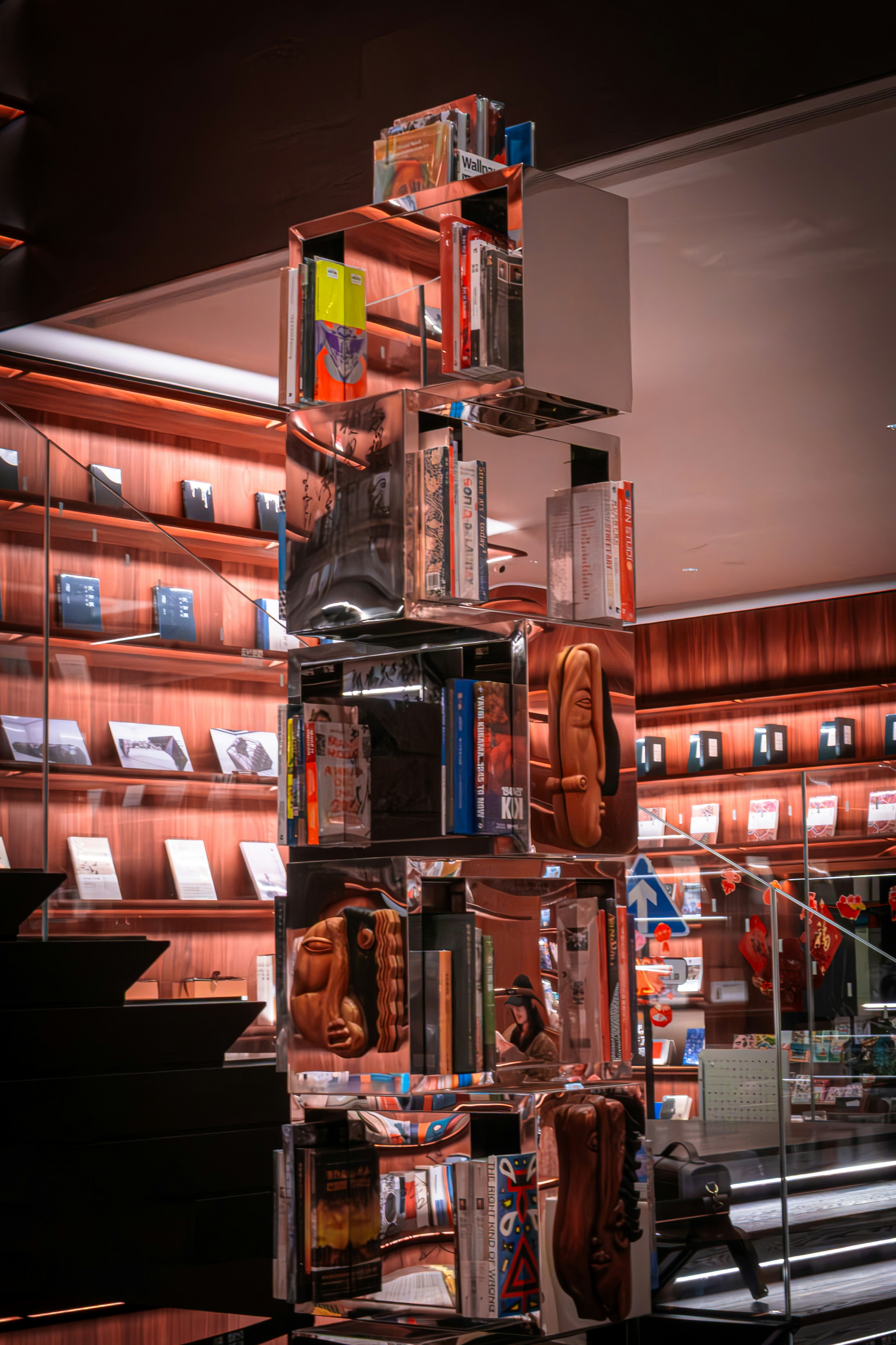 Books displayed in a modern, reflective shelving unit