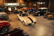 Collection of vintage cars and motorcycle in a garage