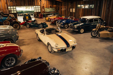 Collection of vintage cars and motorcycle in a garage