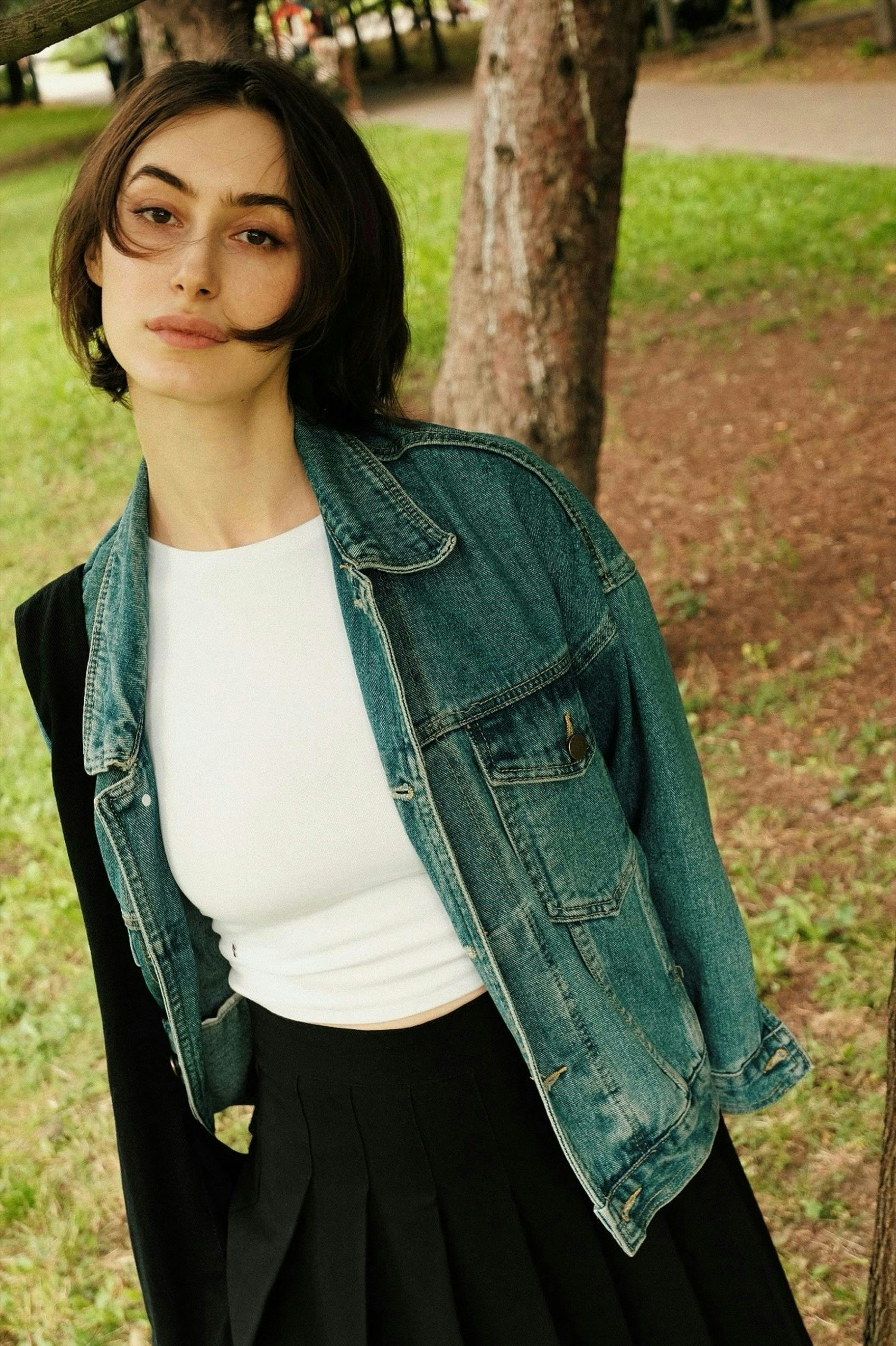 Young woman wearing a denim jacket and skirt outdoors