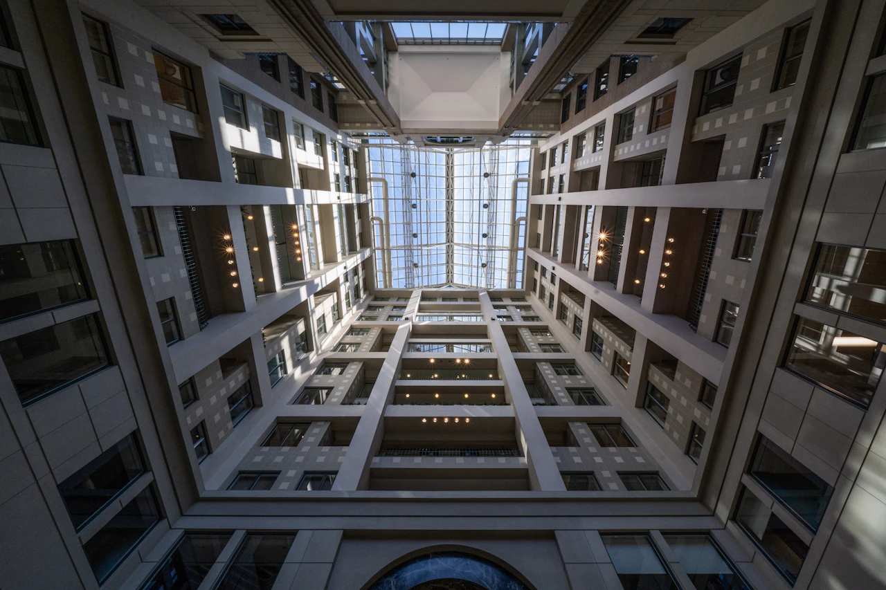 Symmetrical office atrium with a glass skylight, seen from below