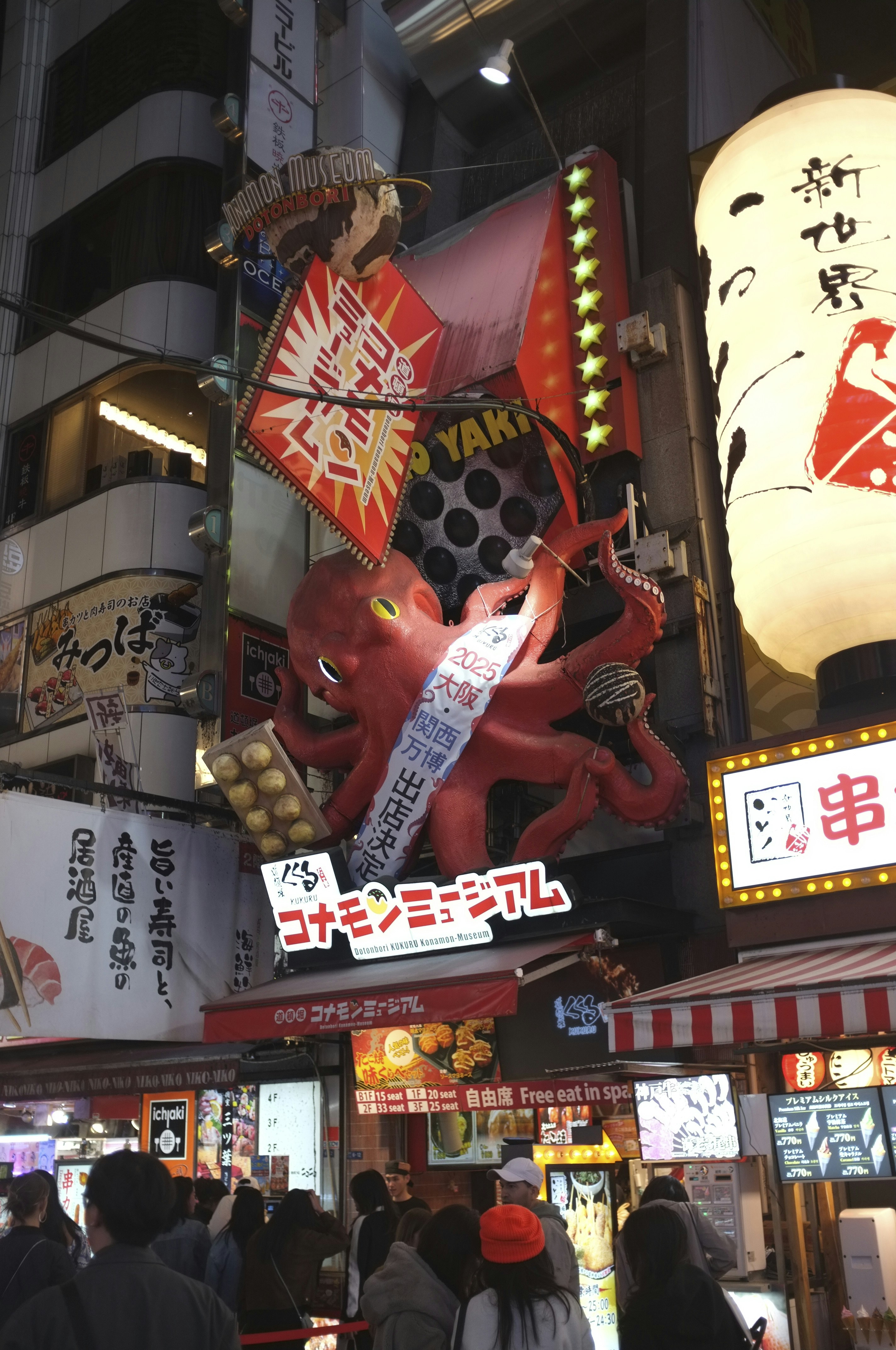 Giant red octopus sign above a busy street