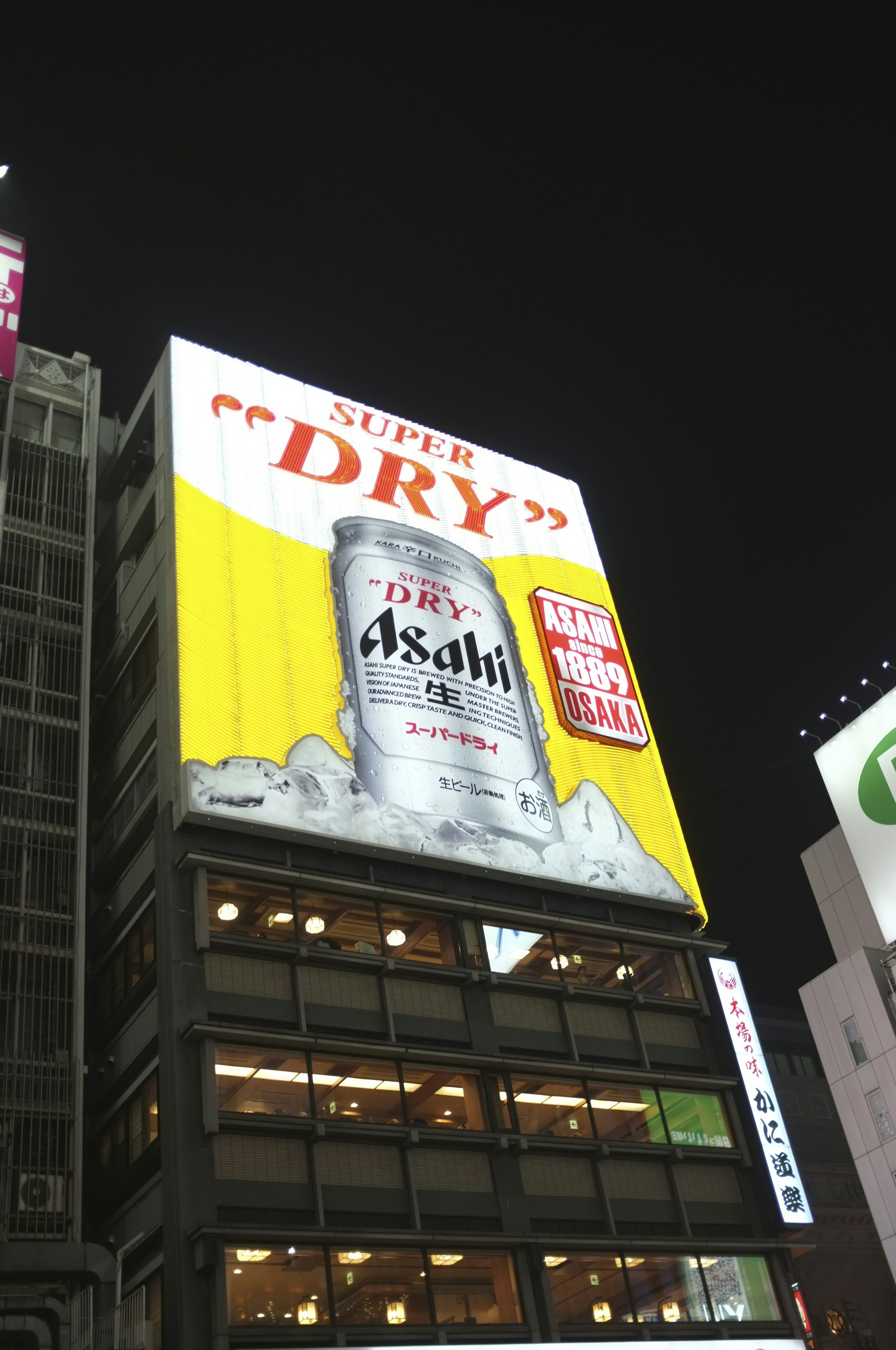 Building with "super dry" asahi beer advertisement at night