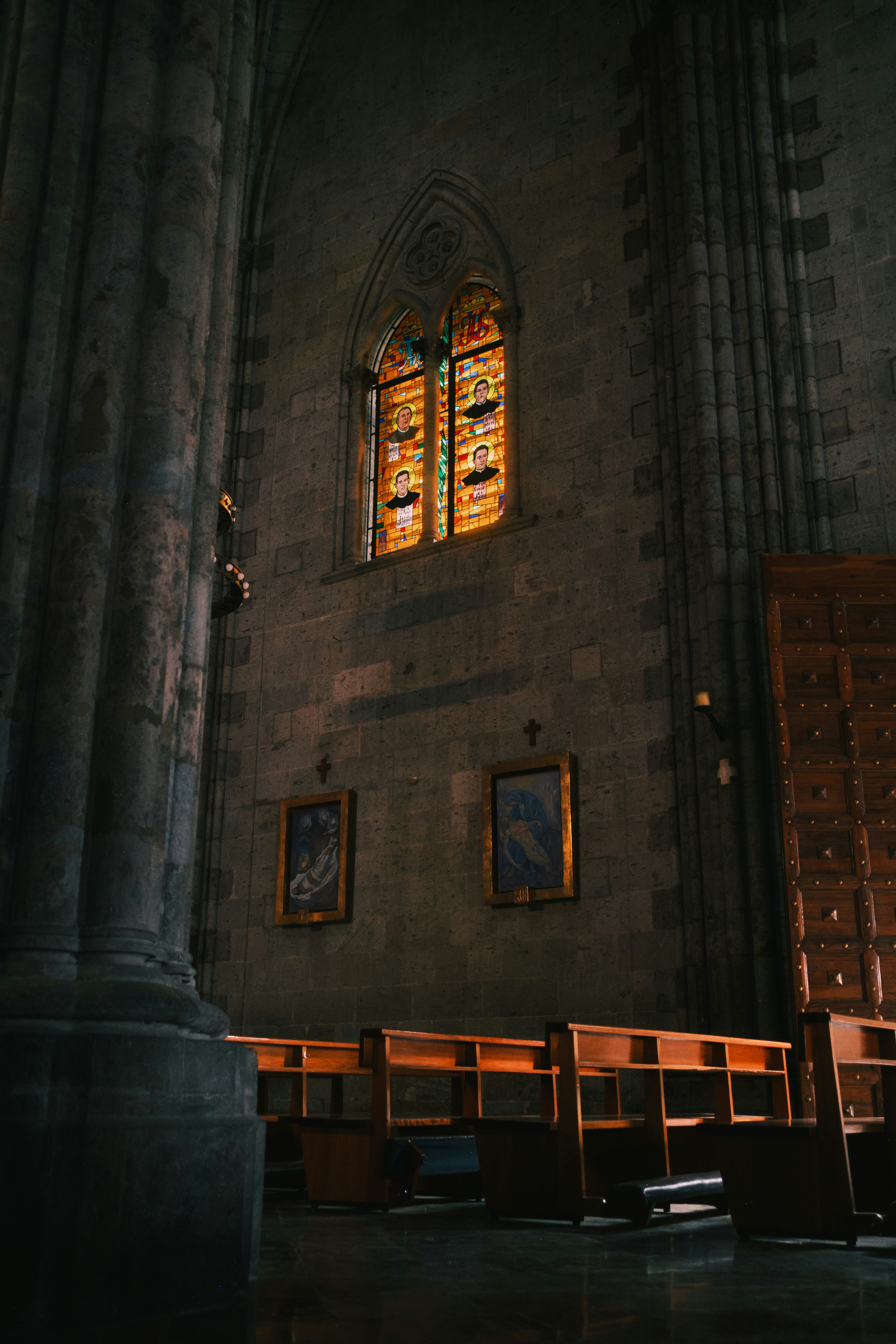Jendela kaca patri di interior gereja batu yang gelap.