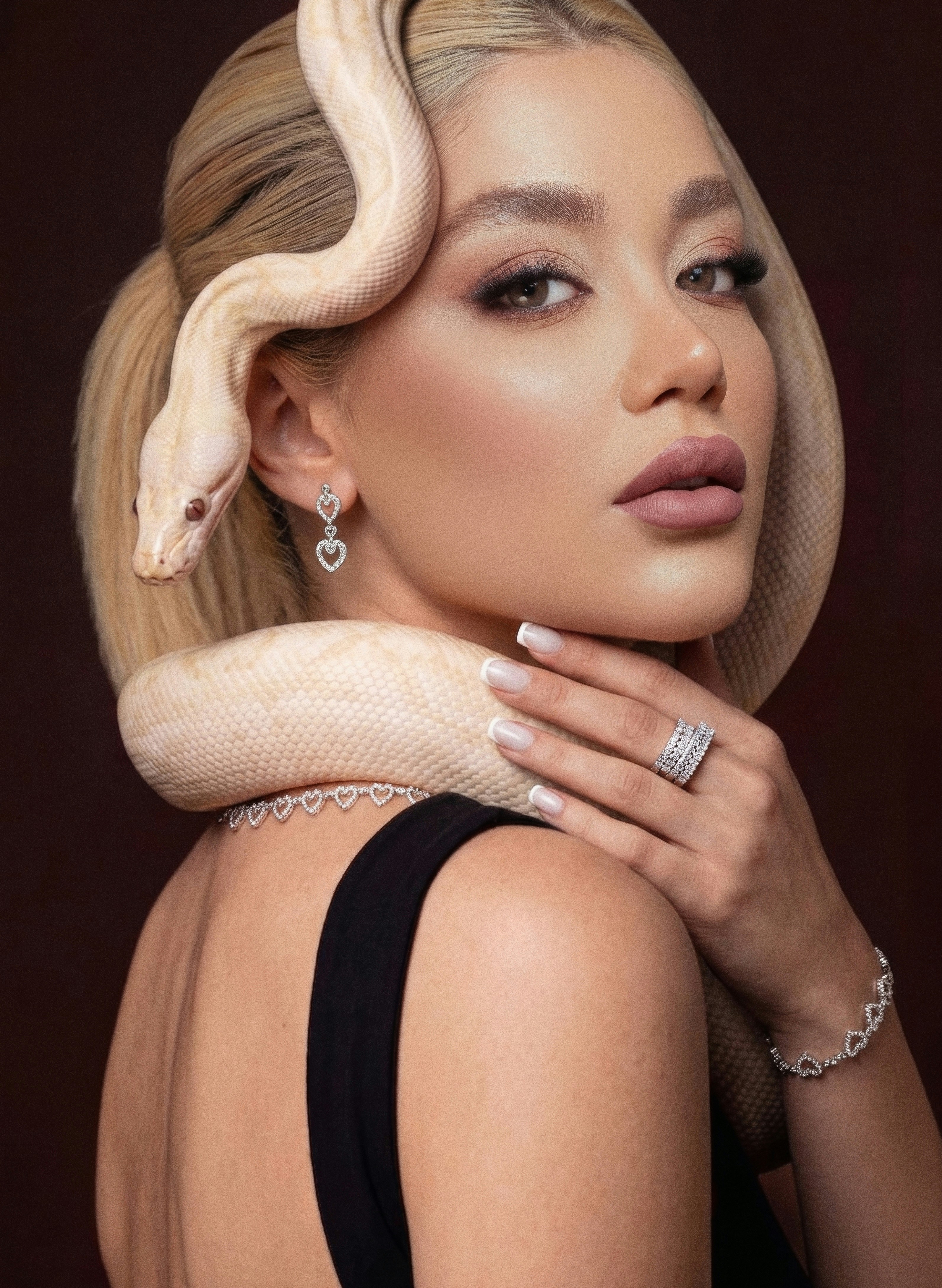 Woman with a white snake around her neck and head