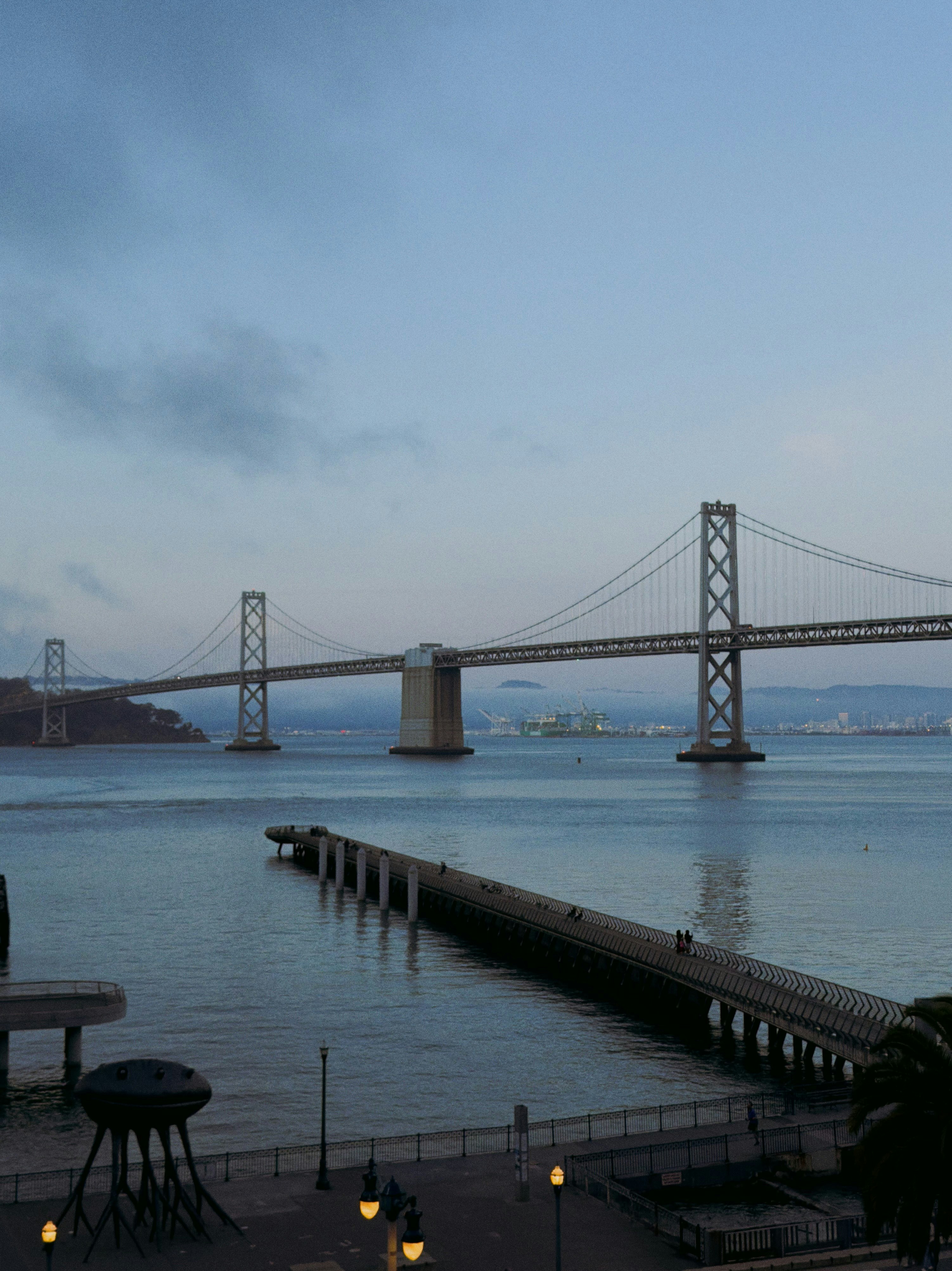 Bay bridge over calm water at dusk