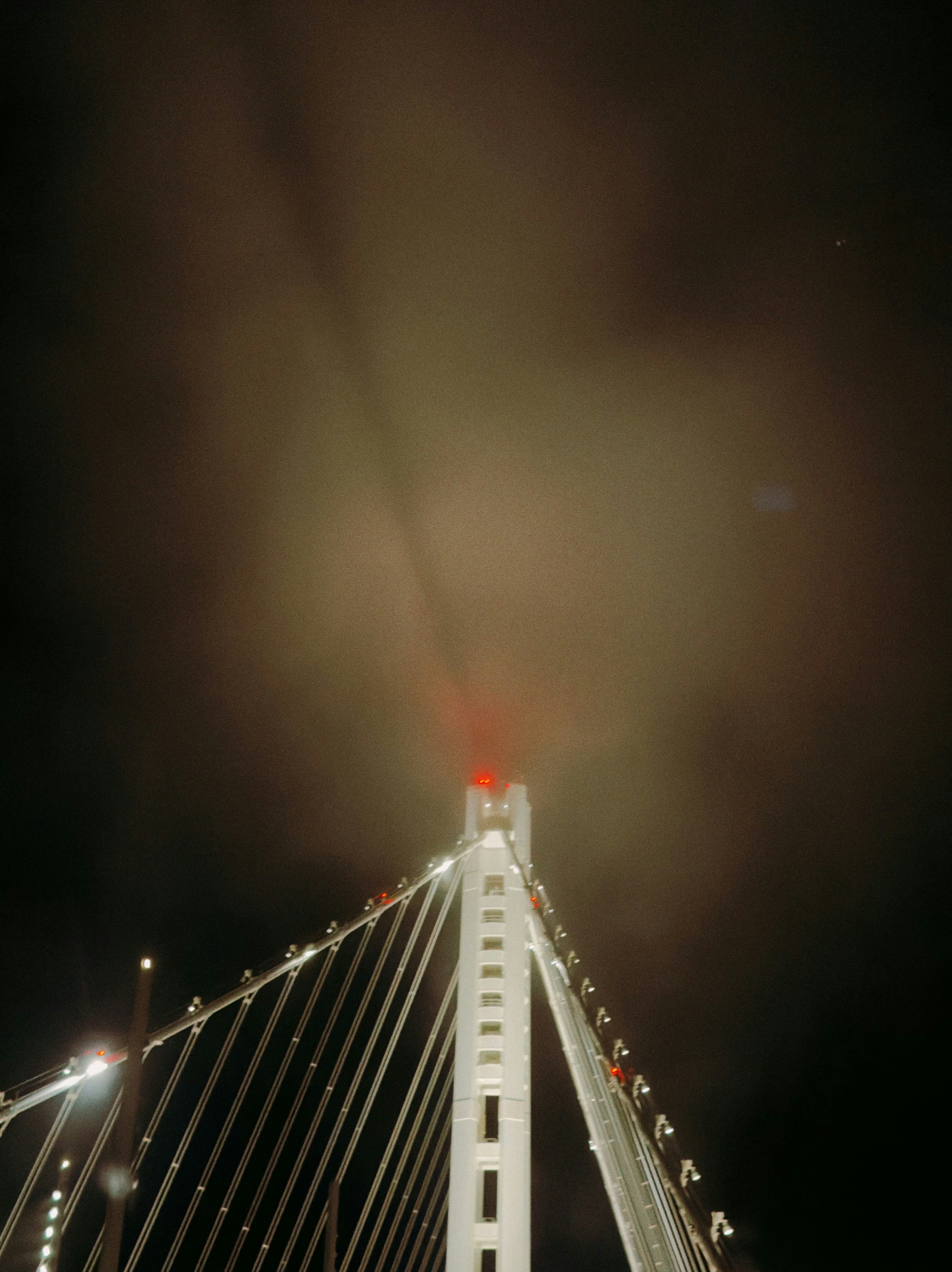Bridge tower emerging from fog at night
