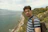 Man with backpack on a cliff overlooking the sea