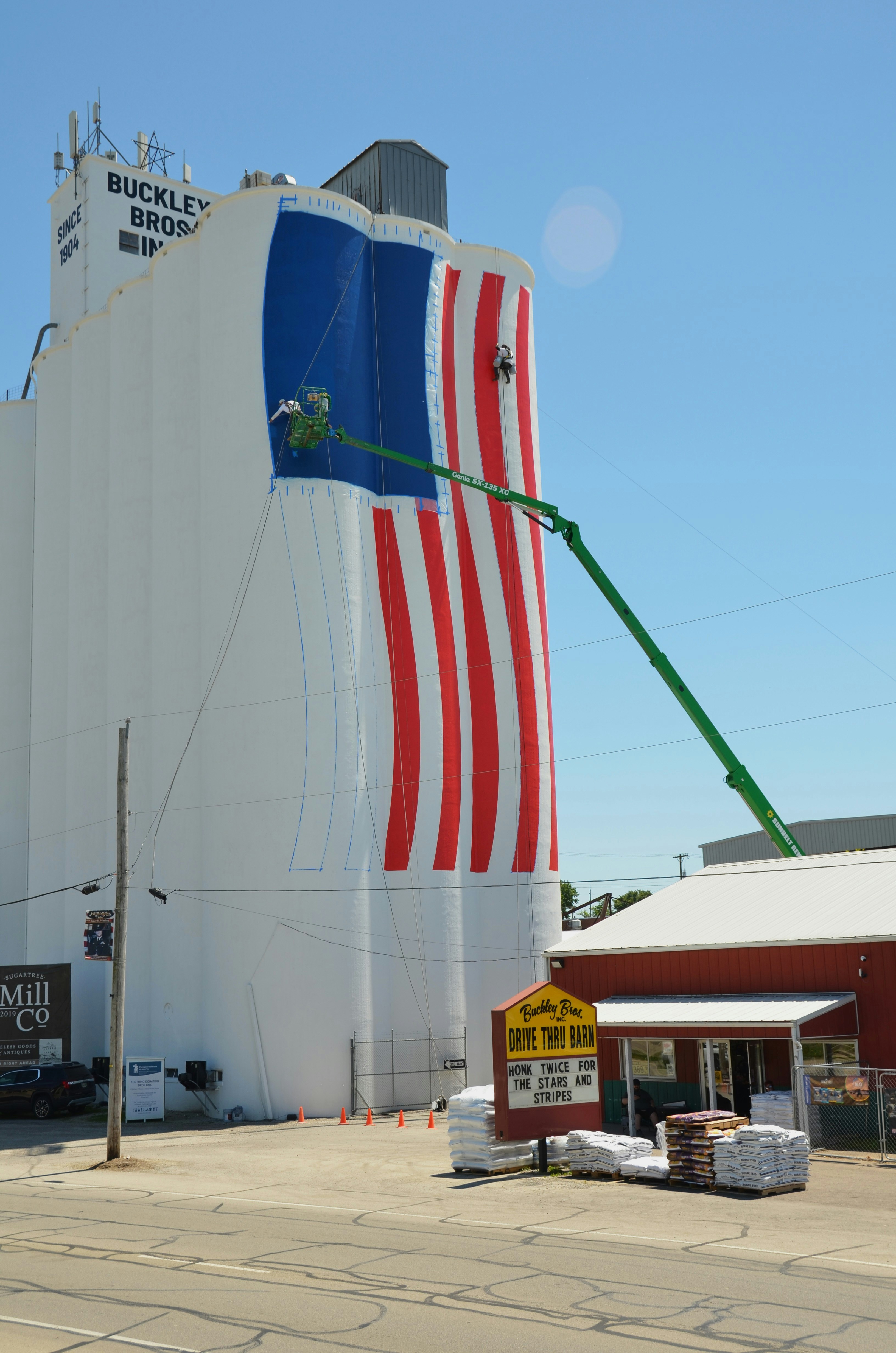 Los trabajadores pintan una enorme bandera estadounidense en un silo de grano.