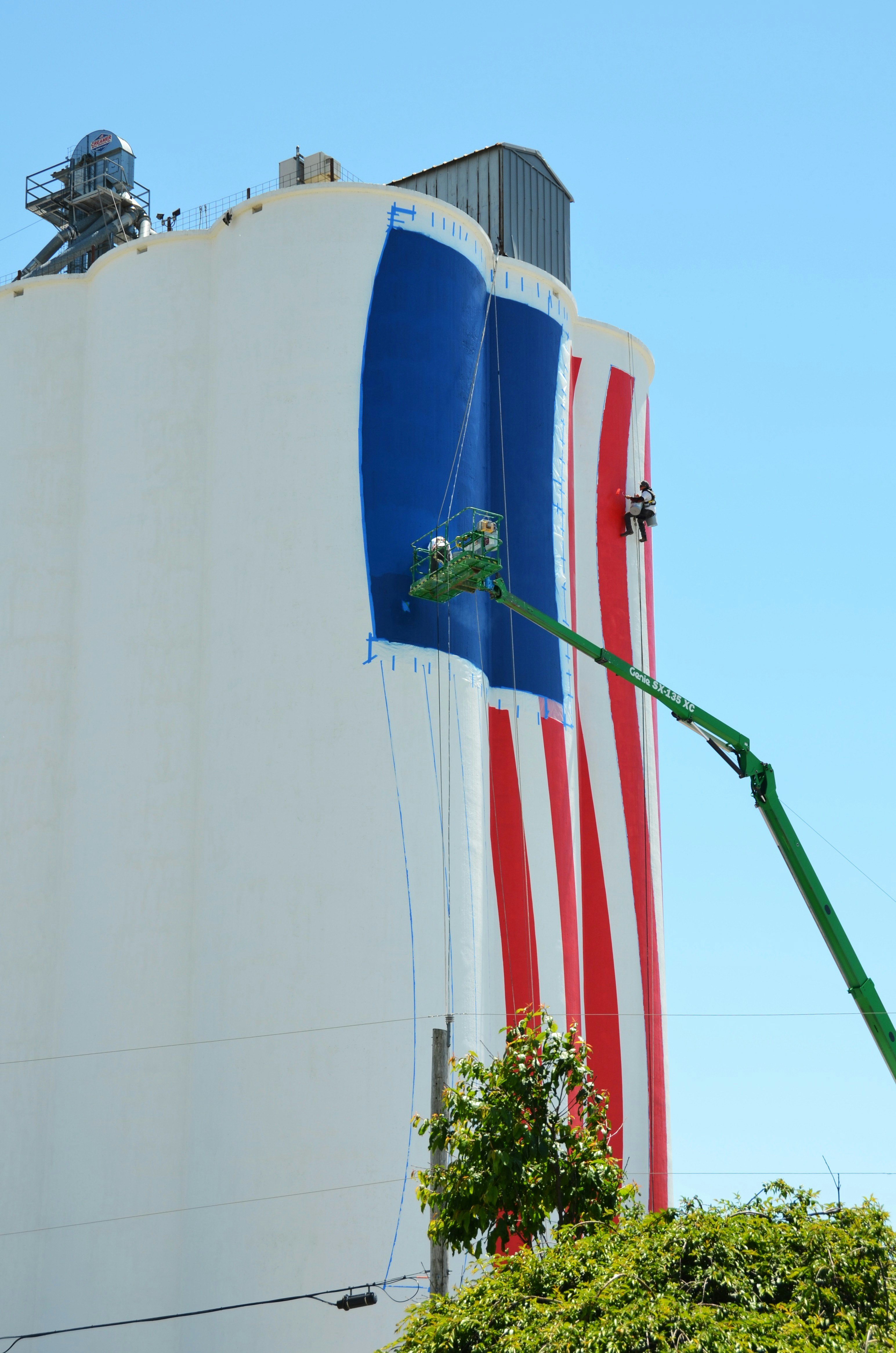 Los trabajadores pintan una enorme bandera americana en un silo.