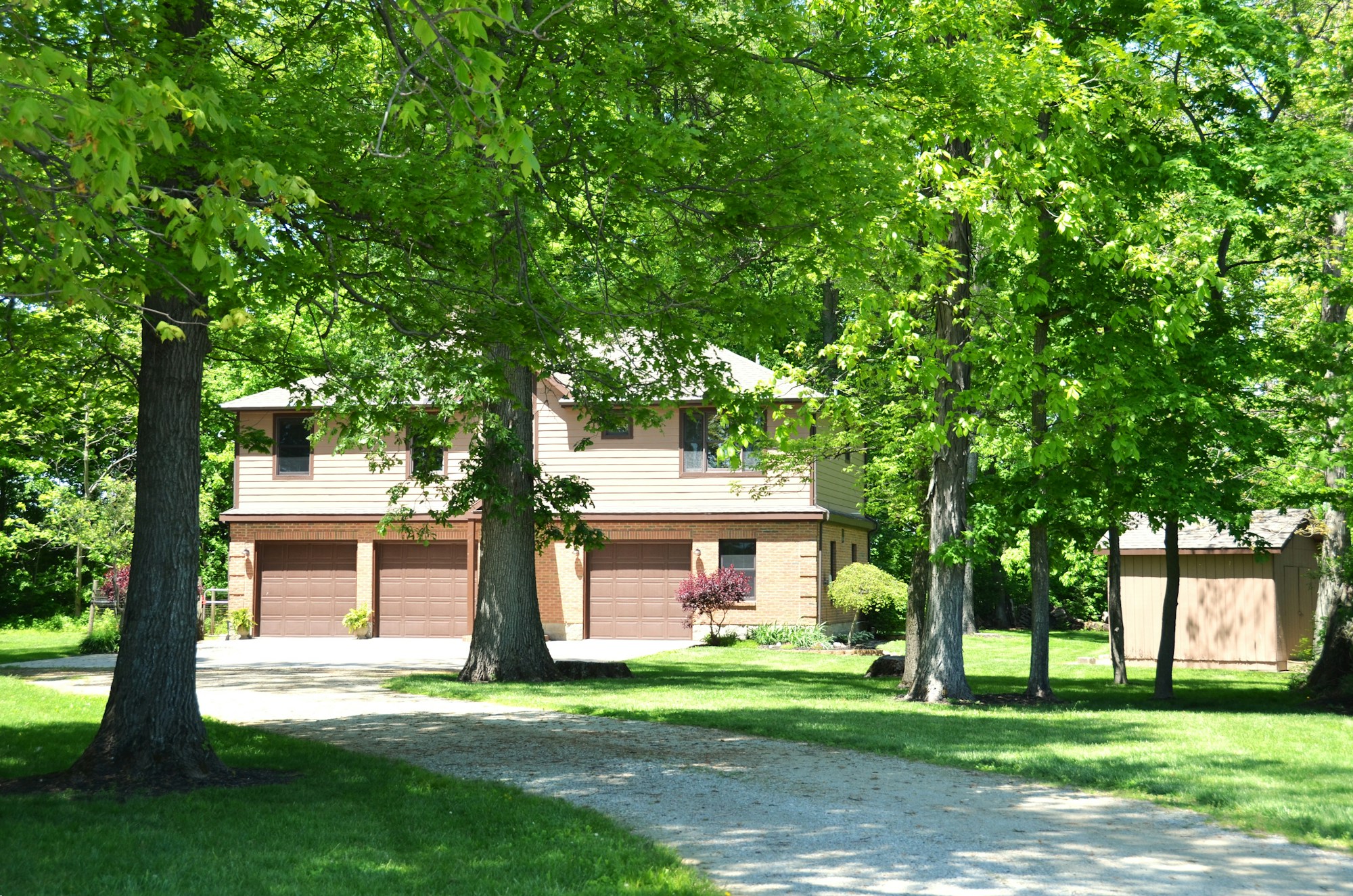 Suburban house with a shared paved driveway running alongside a garage