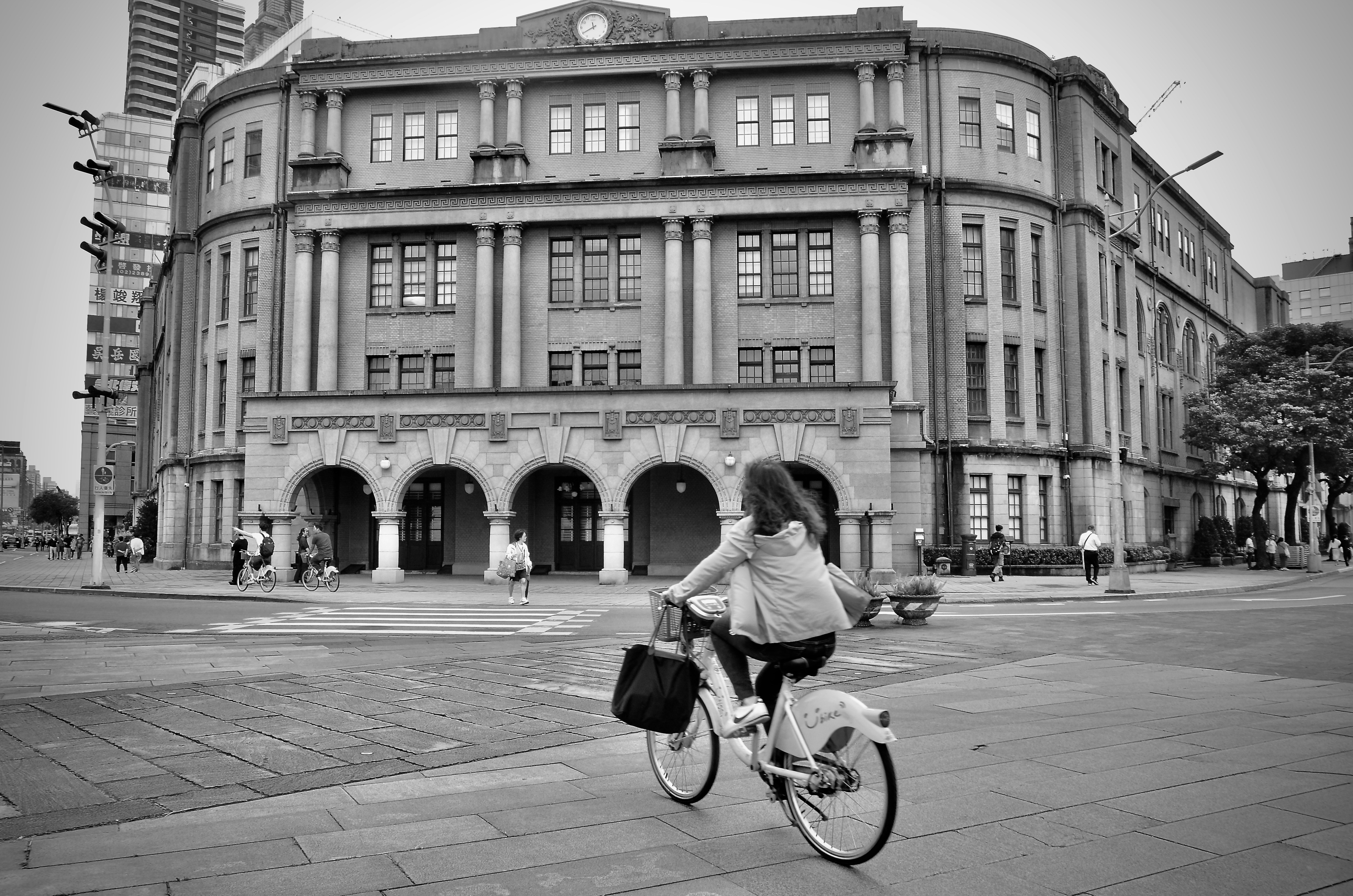 Femme à vélo devant un bâtiment historique